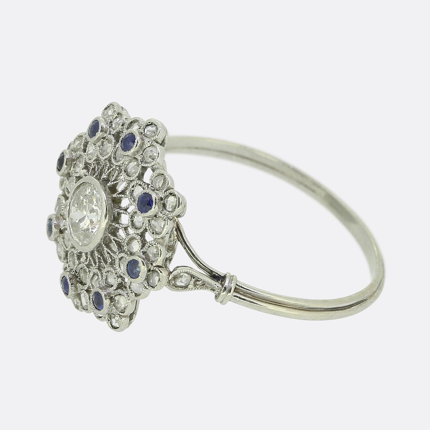 Here we have a wonderful sapphire and diamond cluster ring dating back to the pinnacle of the Art Deco movement. A single round faceted old European cut diamond sits slightly risen at the centre of the face atop an intricately crafted filigree