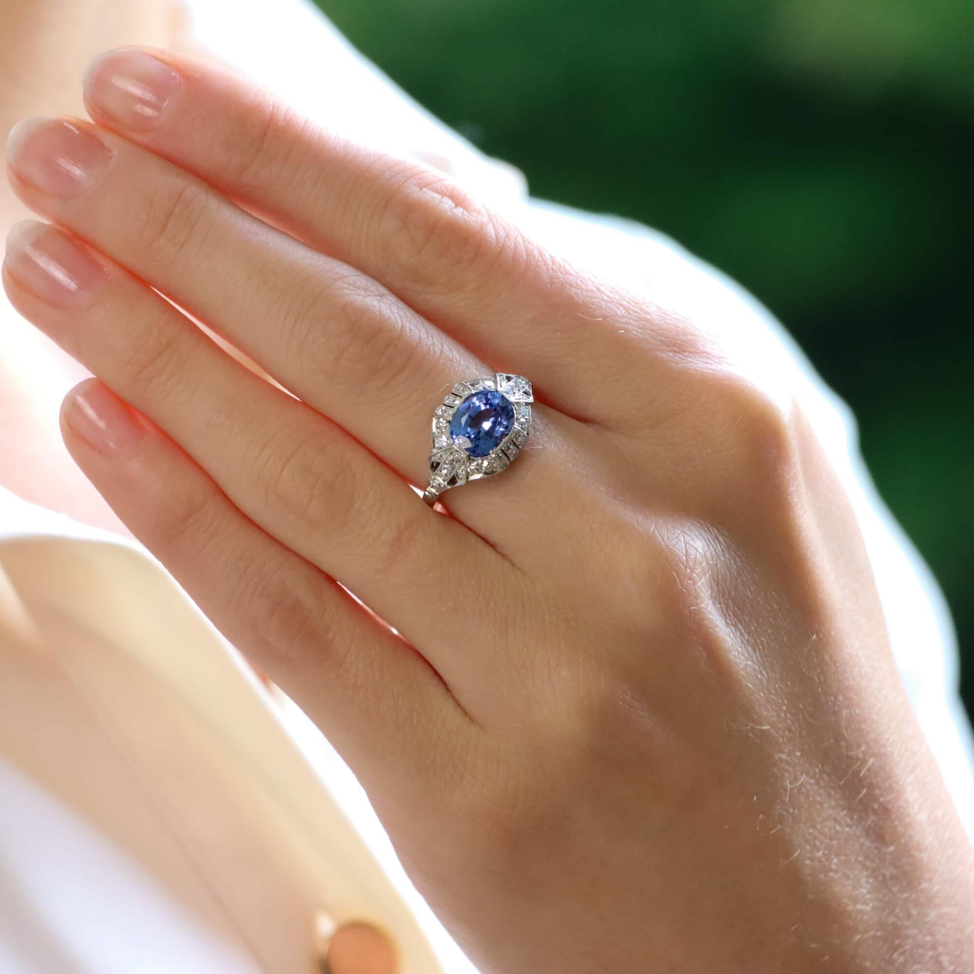 A beautiful Art Deco sapphire and diamond ring, set in platinum.

The ring is composed in a geometric cluster design, set centrally with large oval cornflower blue sapphire. The sapphire is set amongst panels of old cut diamonds which beautifully