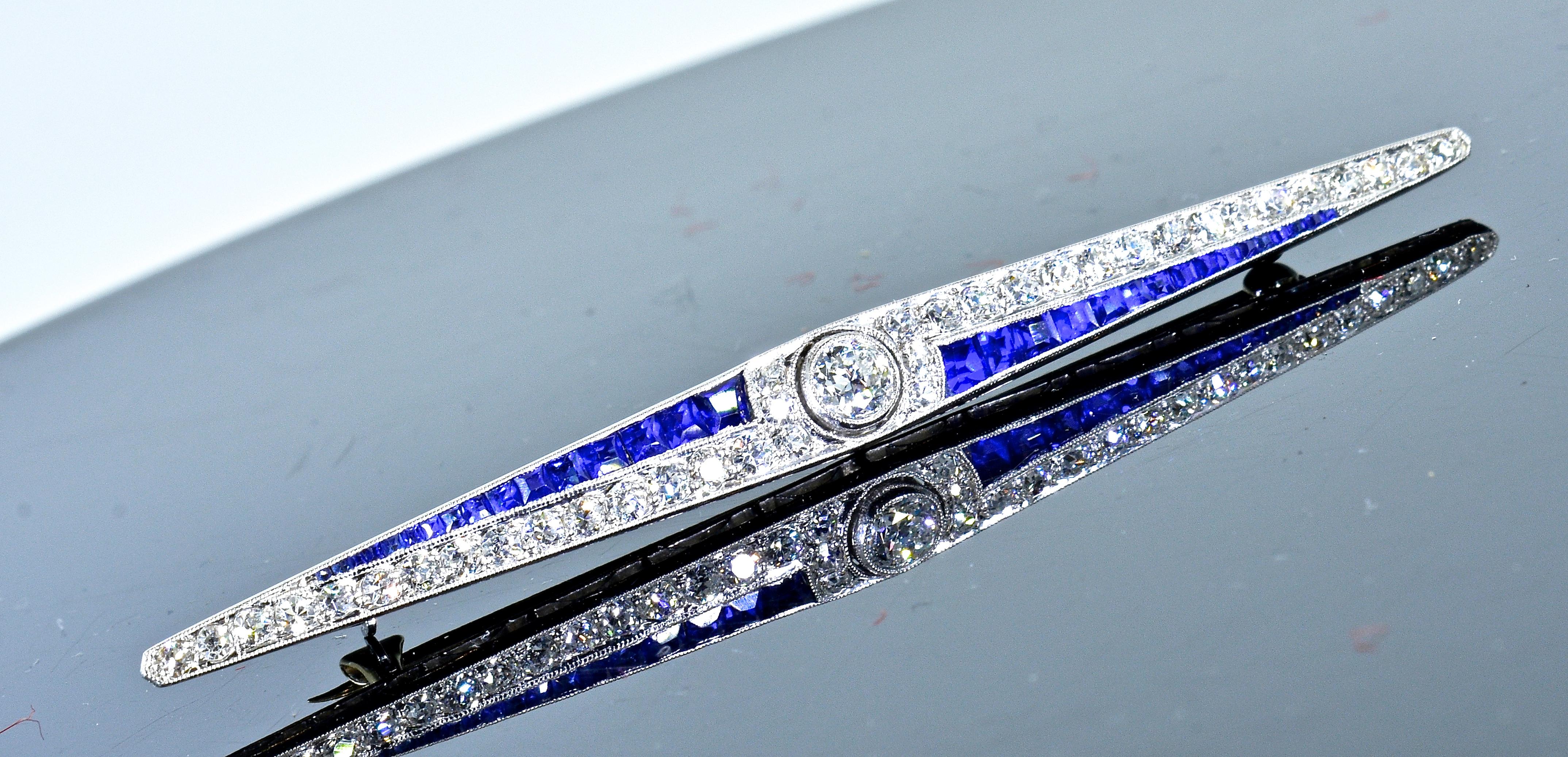 Art Deco platinum pin possessing 32 very fine calibre cut natural bright vivid blue sapphires weighing approximately .50 cts.  The white brilliant cut diamonds are all near colorless, G/H, and very very slightly included to very slightly included