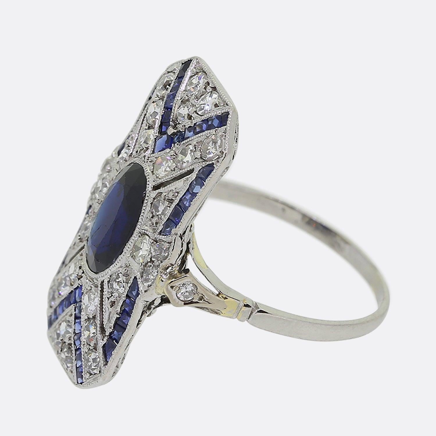 Ecco un sensazionale anello a placca con zaffiro e diamante realizzato in Francia in un'epoca in cui lo stile Art Déco era all'apice del design. Un singolo zaffiro di forma ovale con una profonda tonalità di colore navy si trova al centro di una