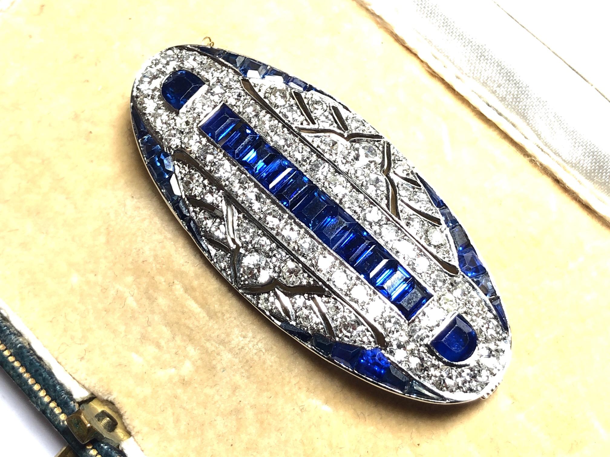 Art Deco sapphire and diamond plaque brooch, oval design set with calibre and baguette cut sapphires, and eight-cut and old cut diamonds, mounted in platinum. Measures approximately 5cm in length, estimated total diamond weight 1.50ct.