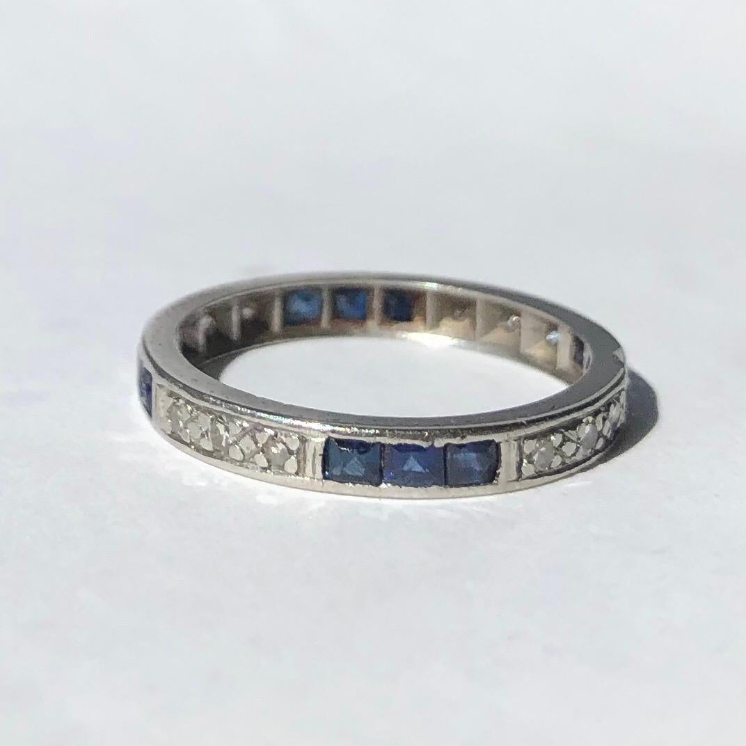 This eternity band holds sapphires and diamonds in clusters of three. The Sapphires measure 5pts each and the diamonds measure 2pts each. The stones are set within the platinum band. 

Ring Size: M 1/2 or 6 1/2,
Band Width: 2mm 

Weight: 2.79g