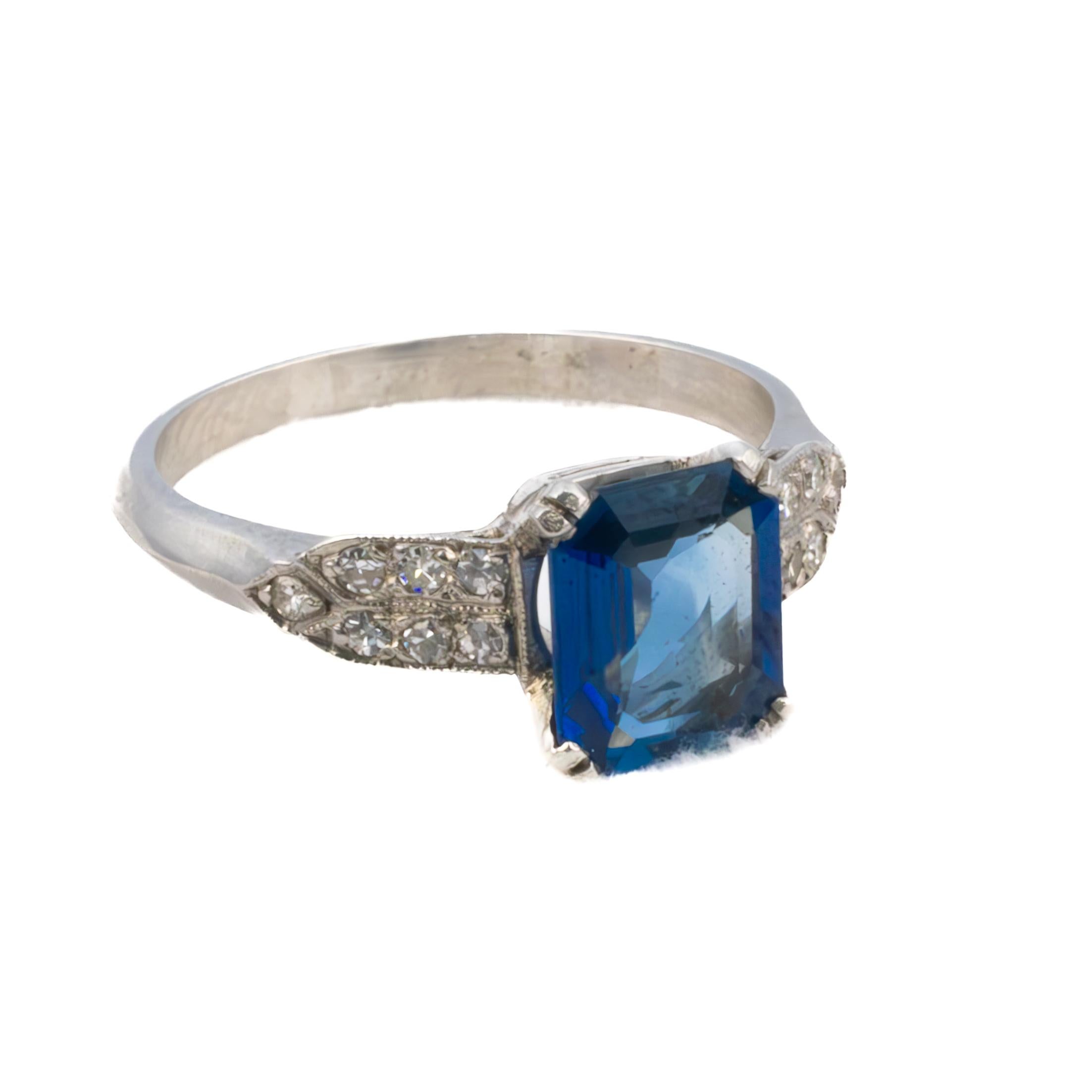 Art Deco Sapphire and Diamond Platinum Ring

A breathtaking Art Deco ring featuring a captivating emerald-cut sapphire with a deep, celestial blue hue, radiating an air of sophistication and refinement. The striking centerpiece is embraced by