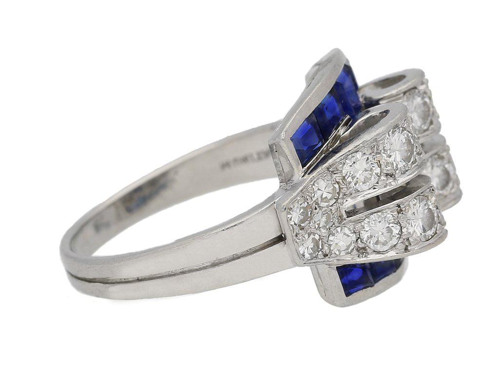 Art Deco sapphire and diamond ring by Tiffany & Co. Set with twelve square baguette cut natural unenhanced sapphires in open back rubover channel settings with a combined approximate weight of 1.20 carats, additionally set with twelve round