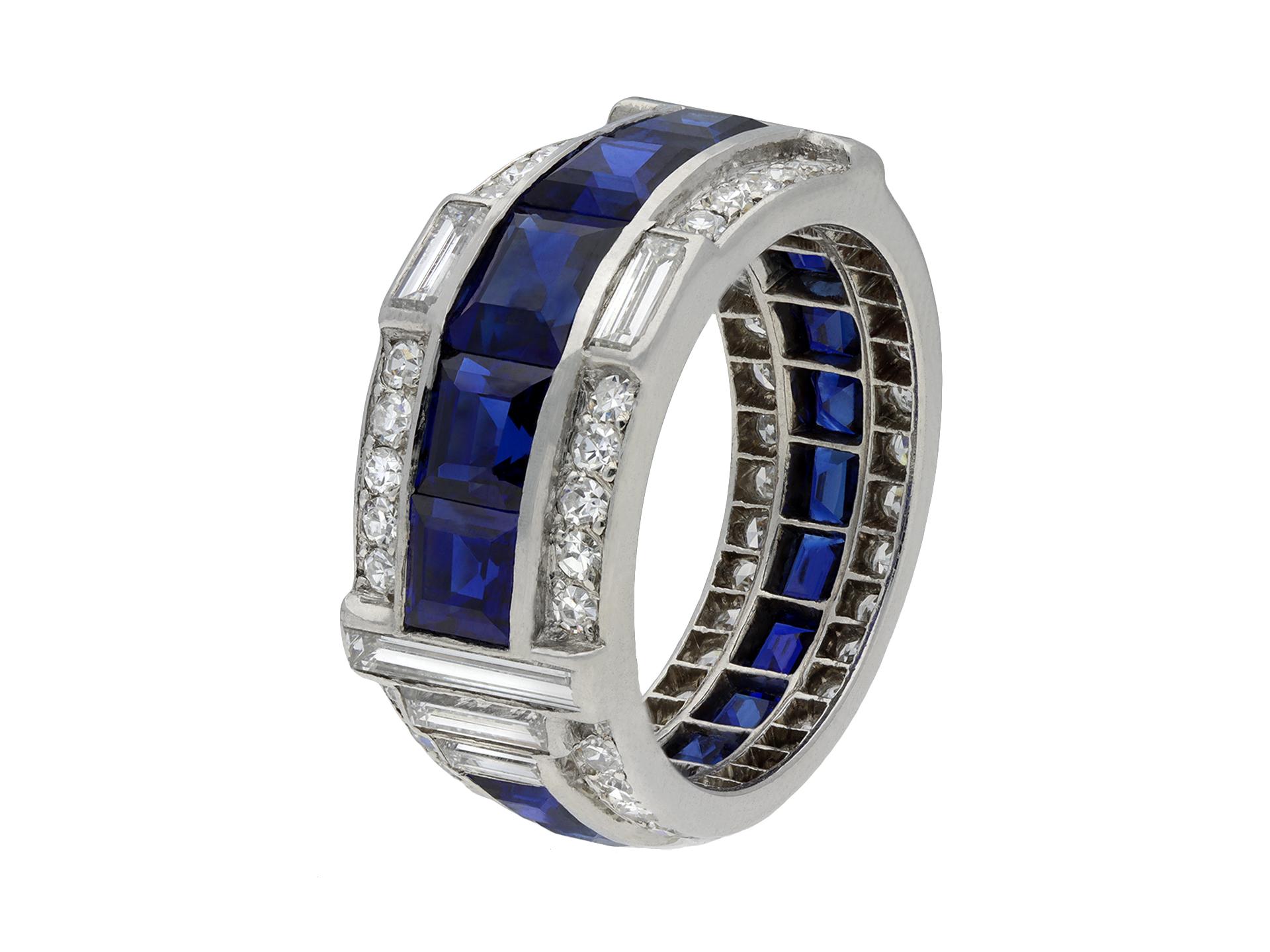 Art Deco sapphire and diamond ring. Set with sixteen calibre cut natural unenhanced sapphires, graduating in size, in open back channel settings with an approximate combined weight of 4.50 carats, further set with sixty-six round eight cut diamonds
