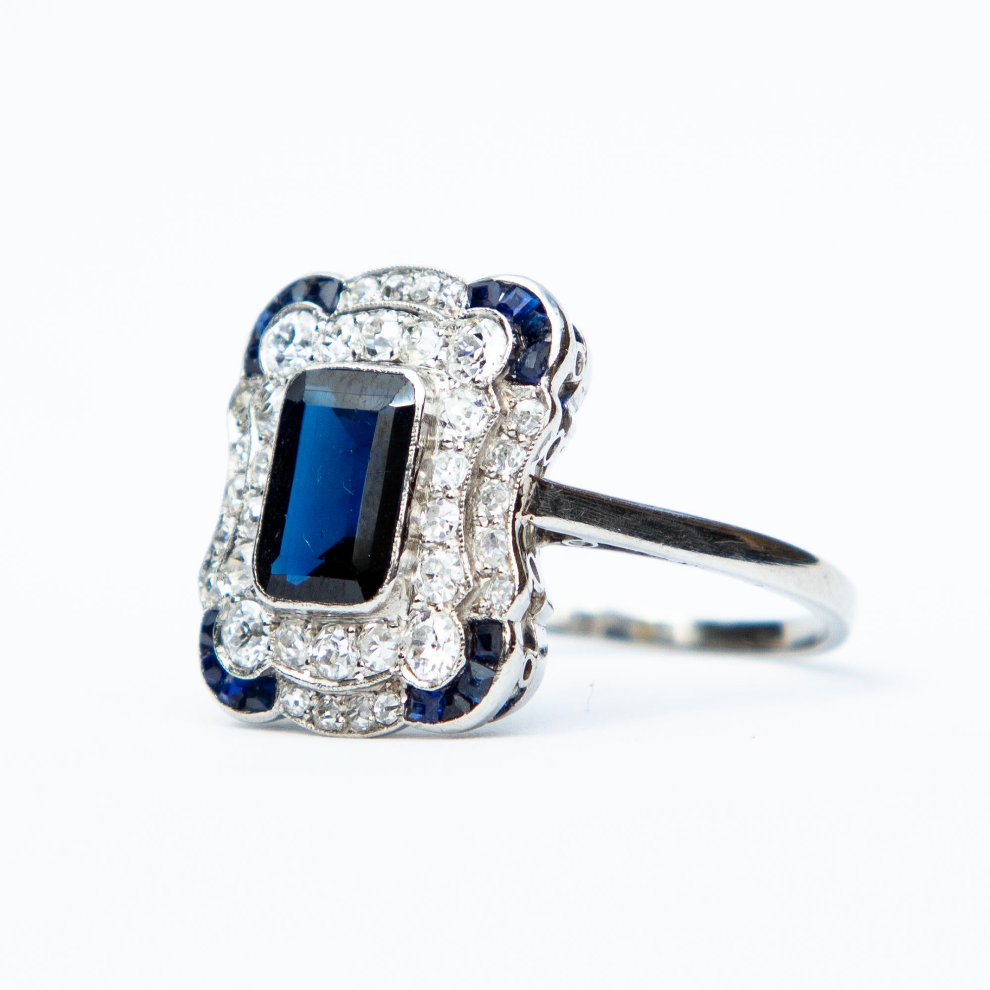 A spectacular example of an Art Deco Diamond and Natural Sapphire ring. 
The central sapphire measures just over 1 carat, surrounded by old European cut Diamonds and sapphire accented corners. This wonderful piece is Platinum set.
The Diamonds are H