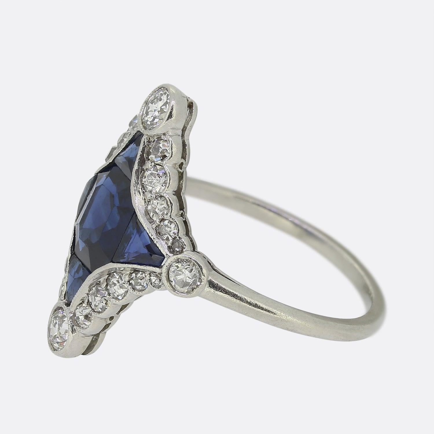 This is a truly special and unique ring that dates back to the Art Deco era. The ring features a central emerald cut sapphire that is flanked on all sides by perfectly matched triangular sapphires. The stones have been exceptionally cut and this