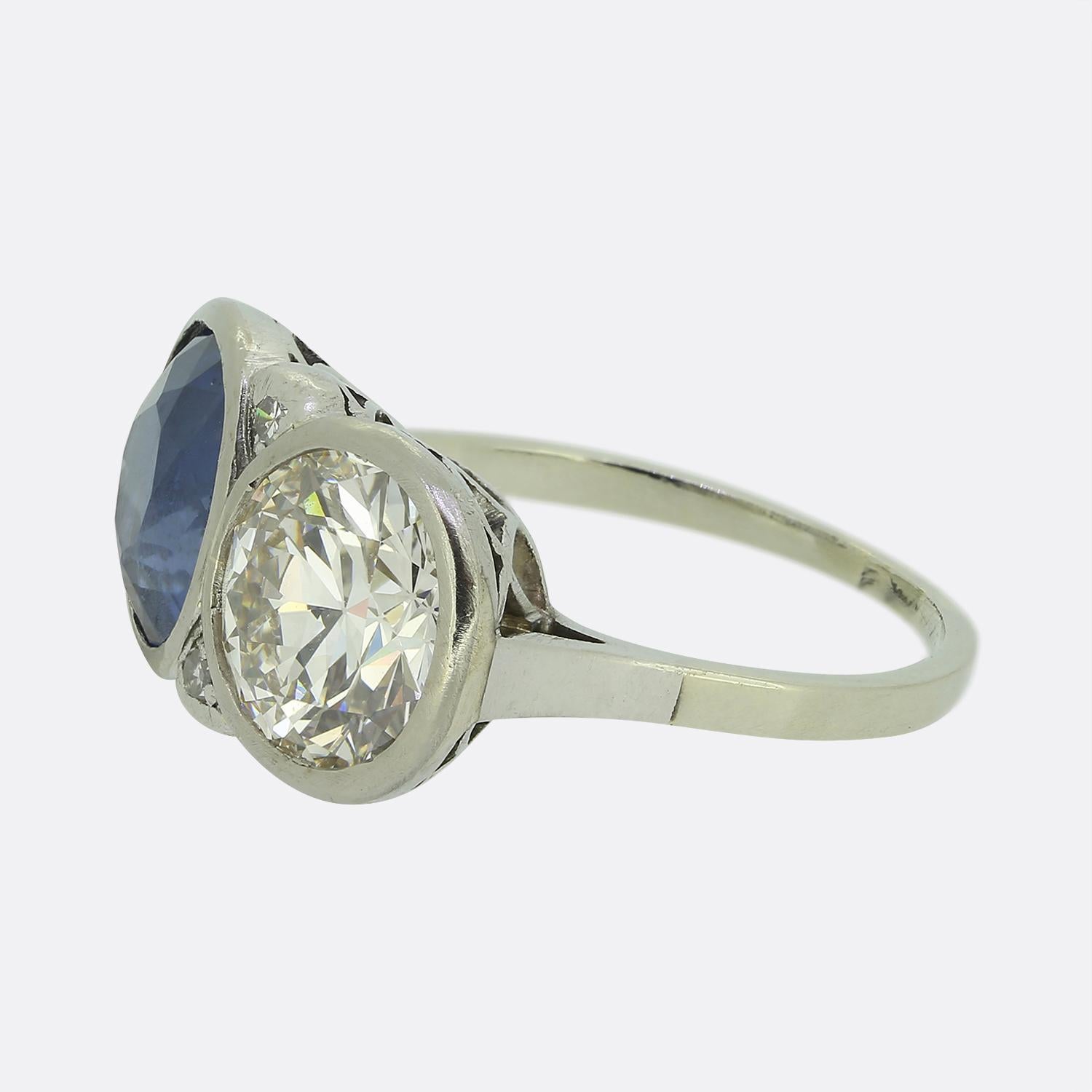 Here we have an outstanding two-stone ring crafted during the pinnacle of the Art Deco movement. This platinum piece features a round faceted sapphire easily surpassing 3.00ct in weight and possessing a medium indigo blue colour tone. This natural