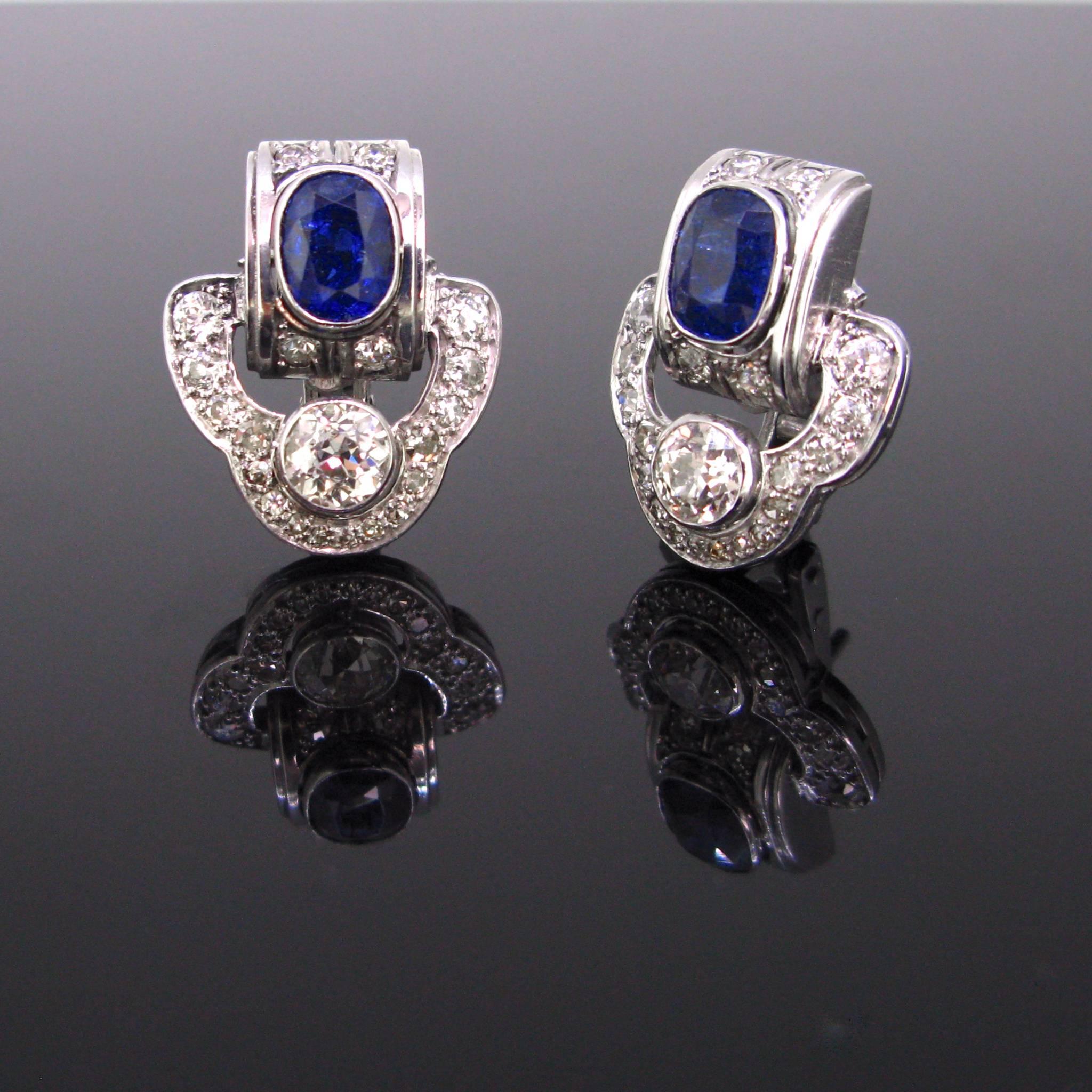 This beautiful pair of earrings is directly from the Art Deco ear with its geometric design. Each earring features a natural sapphire weighing approximately 1.35ct each and one Old European Cut diamond of about 0.60ct as well as 20 smaller Old