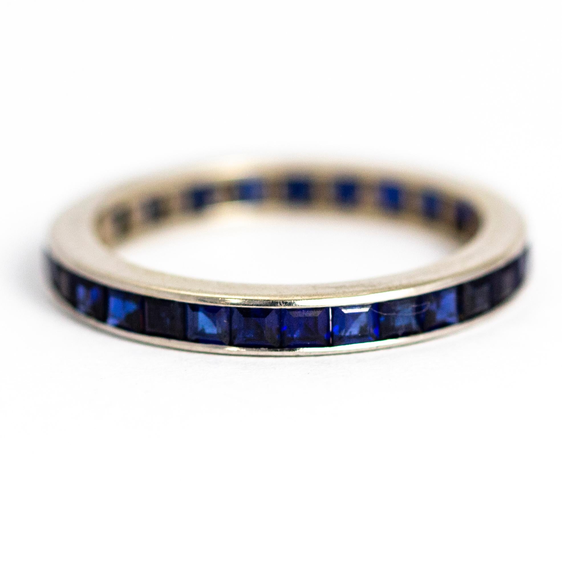 This stunning sapphire eternity band hosts beautiful deep blue square cut sapphires all the way around. This would be beautiful on its own or paired with another stunner!

Ring Size: M 1/2 or 6 1/2

Band Width: 2.68mm

Depth to Finger: 2.15mm