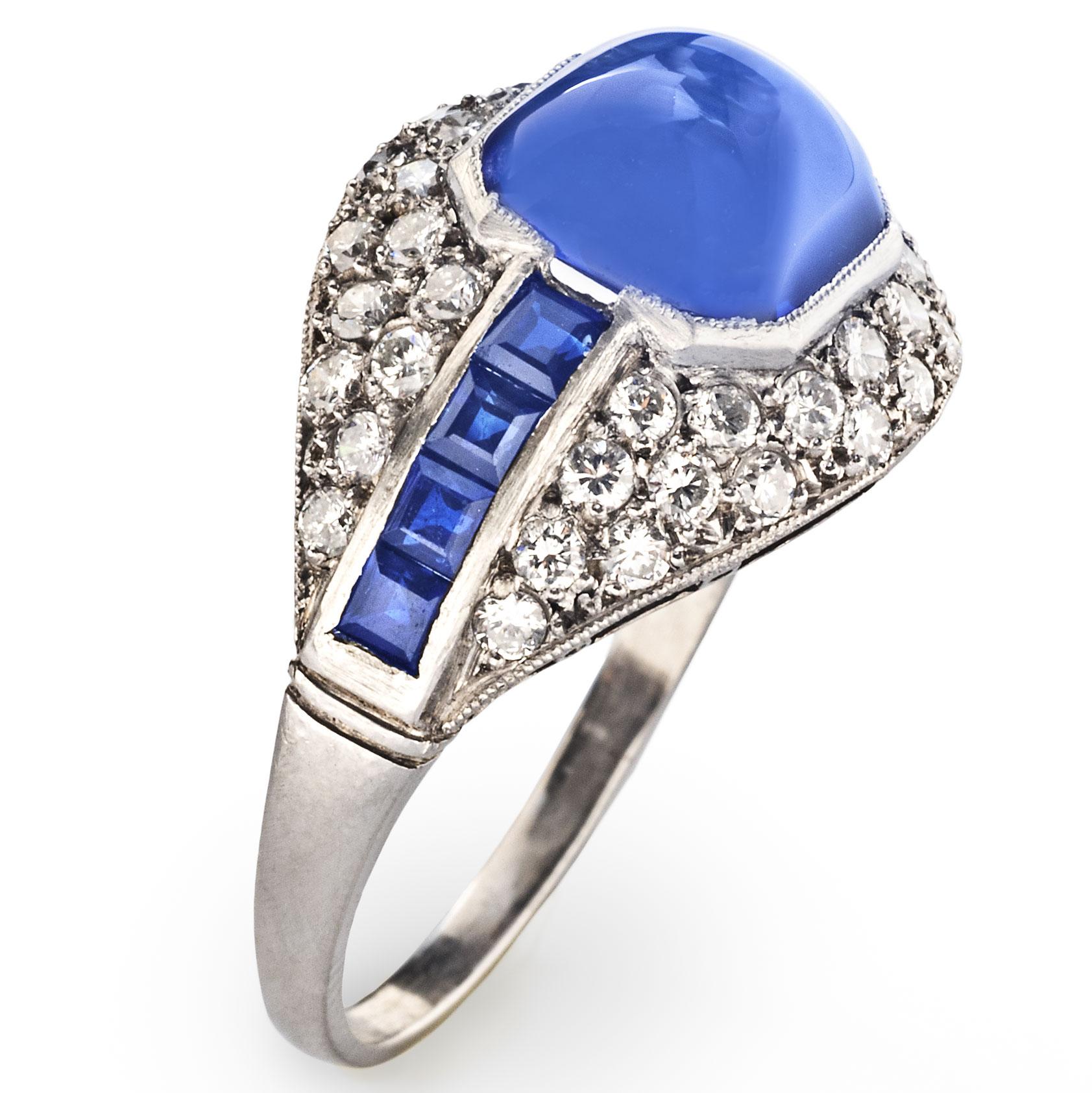 An elegant ring for everyday wear, this vintage Art Deco piece centers on a cabochon sapphire flanked by square cut sapphires in a diamond pavé setting.

Size 8
One cabochon sapphire weighing approximately 3.49 carats
Eight square cut sapphires