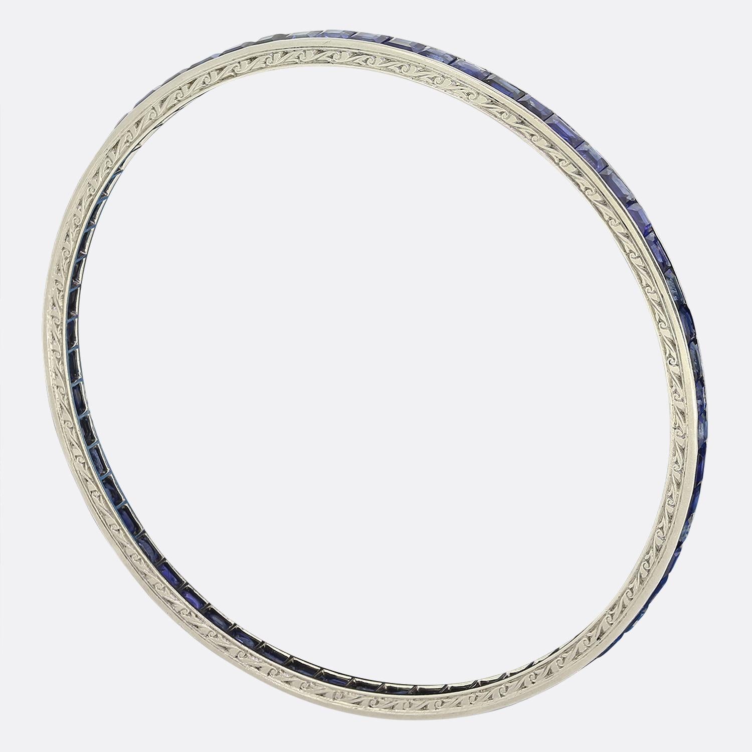 Ecco un meraviglioso braccialetto con zaffiro realizzato durante l'apice del movimento Art Déco. Gli zaffiri blu di forma quadrata e taglio baguette sono meticolosamente incastonati in una linea continua che circonda l'intero bordo esterno. Gli