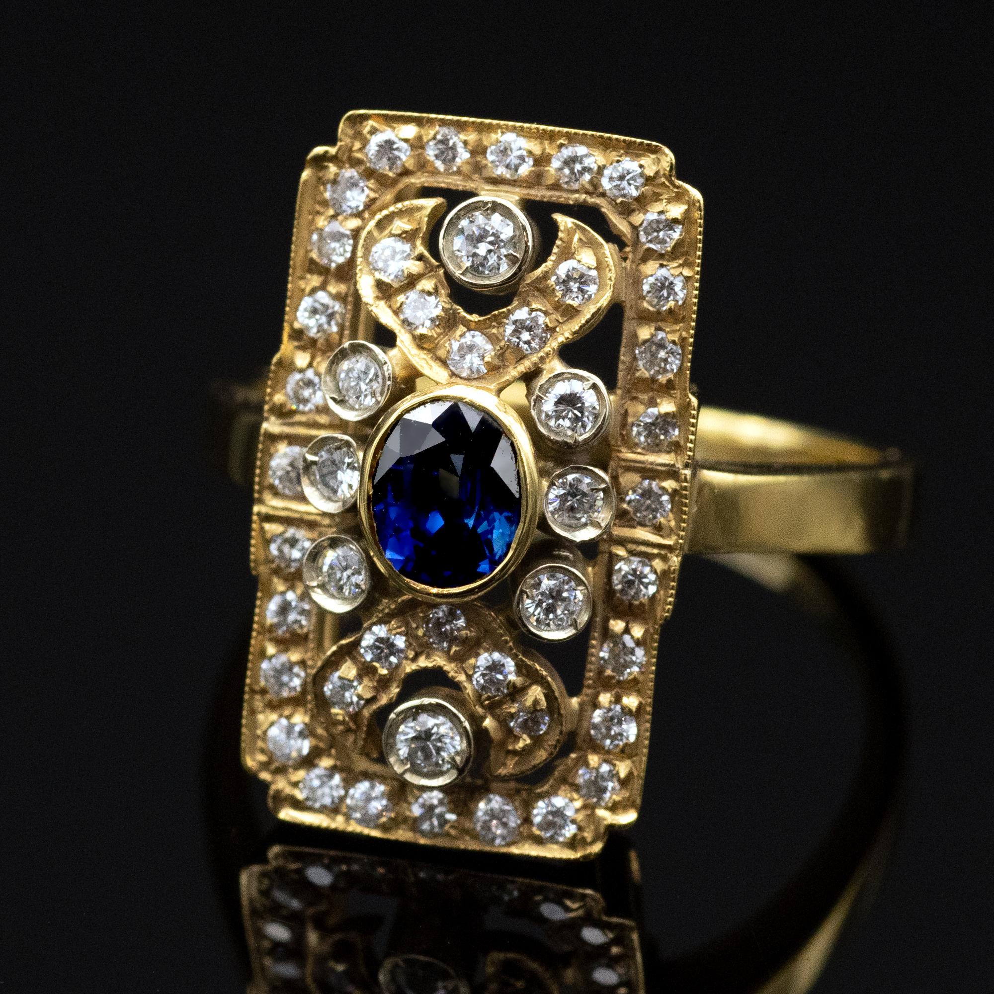 Elegant rectangular two tone sapphire and diamond ring.  The intricate design is very well made combining several types of settings ( from bezel set to millegrain ) and techniques.
The sapphire is rich blue and the diamonds G VS .