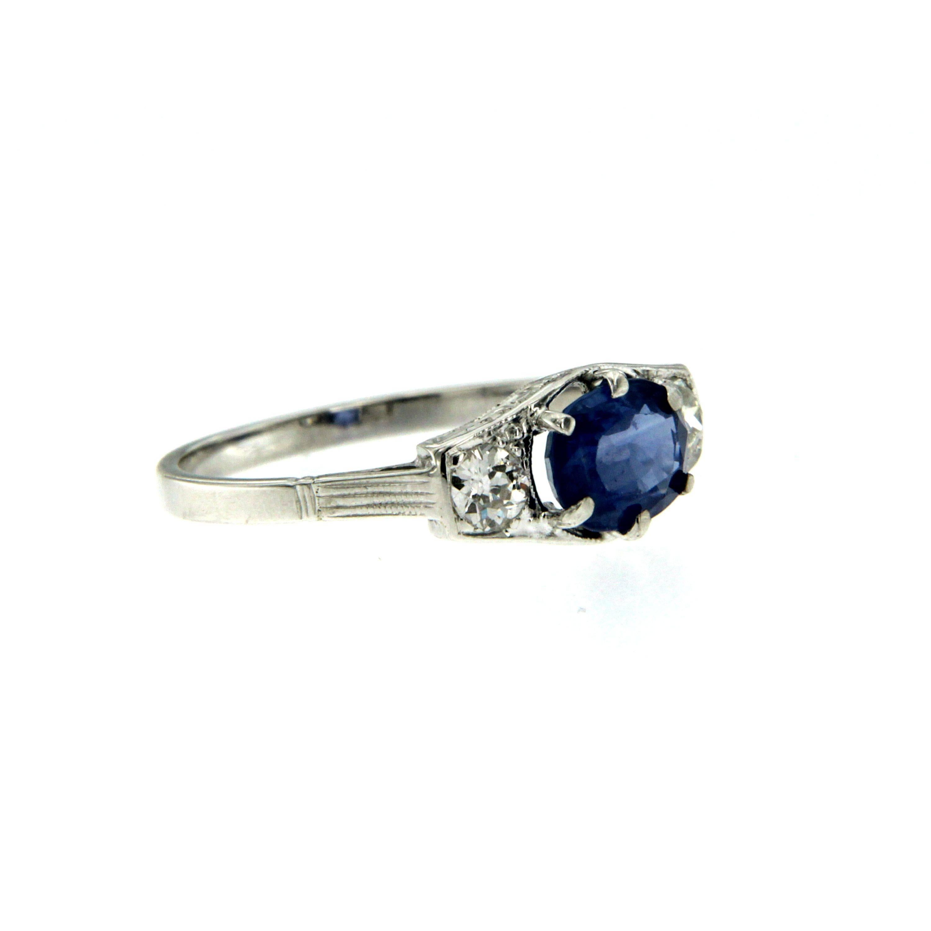 This beautiful Sapphire and Diamond Art Deco ring is hand crafted in solid 18k white gold and it is set with a stunning, Blue oval cut Natural Ceylon Sapphire weighing 0.70 carats, flanked by 2 Round brilliant cut diamonds colorless Vvs clarity