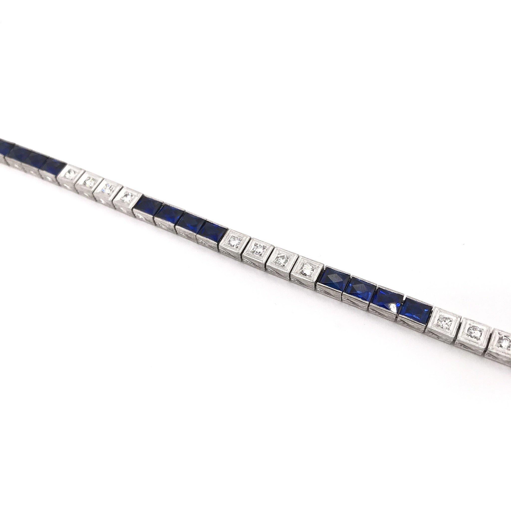 This antique piece was handcrafted sometime during the Art Deco design period ( 1920-1940 ). The 18k white gold bracelet features a combined total weight of one carat of diamonds. The bracelet also features 20 bright sparkling synthetic blue