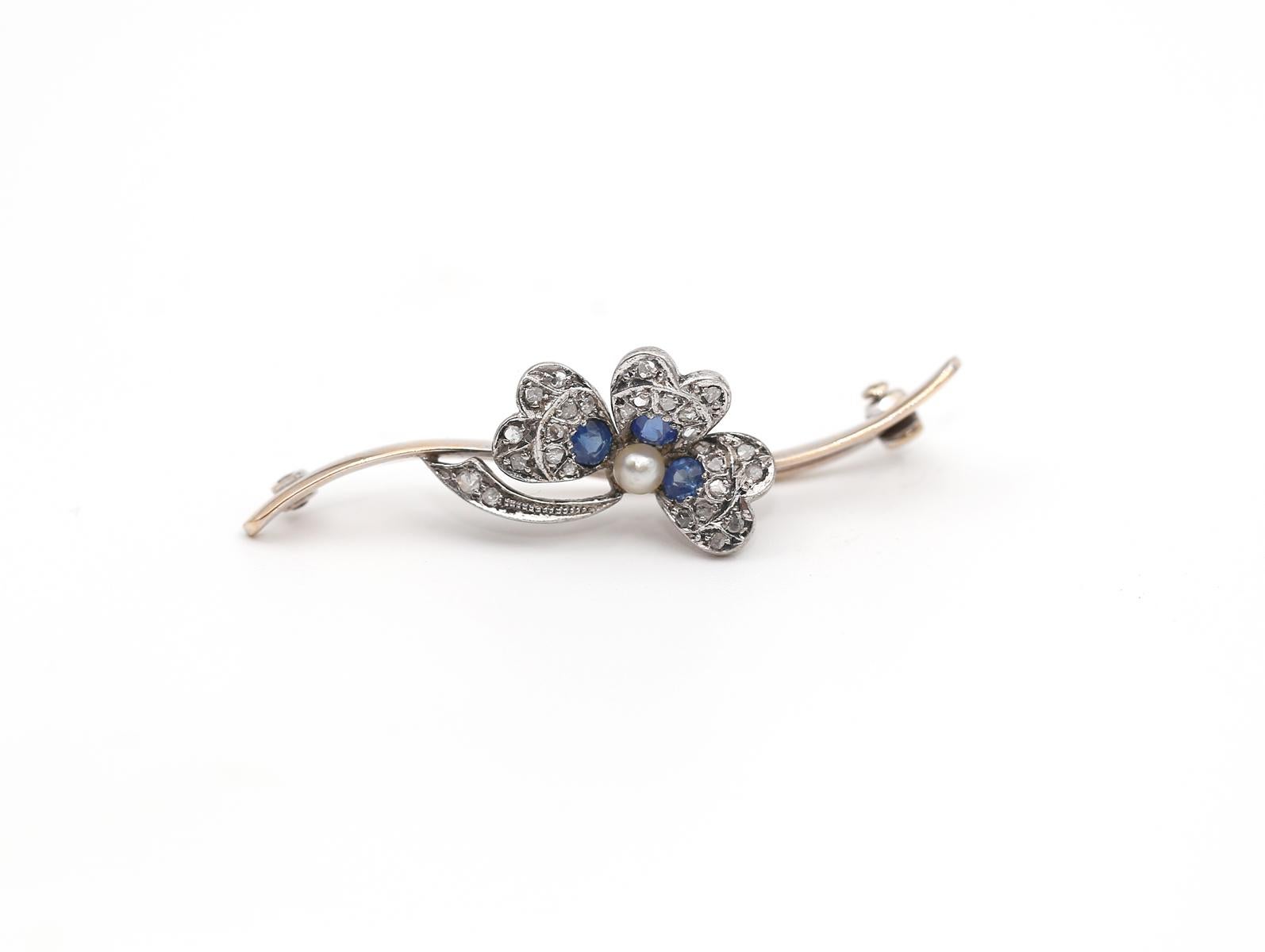 Art Deco Sapphire Diamond And Pearl Floral Brooch, created around 1900, this fine brooch represents a great example of the Art Deco era. Using floral ornamentation as a main theme. The flower appears really gentle and has fine detailing. A fine