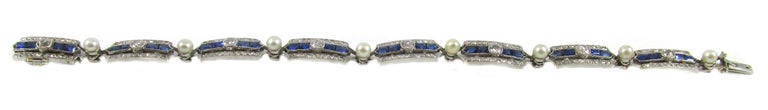 This amazingly hand-crafted French Art-Deco bracelet from ca. 1925 features 8 rectangular panels each set with 2 rectangular step-cut and 2 bullet-shape step cut royal blue sapphires. In the center of the sapphires, a bright white and sparkly Old