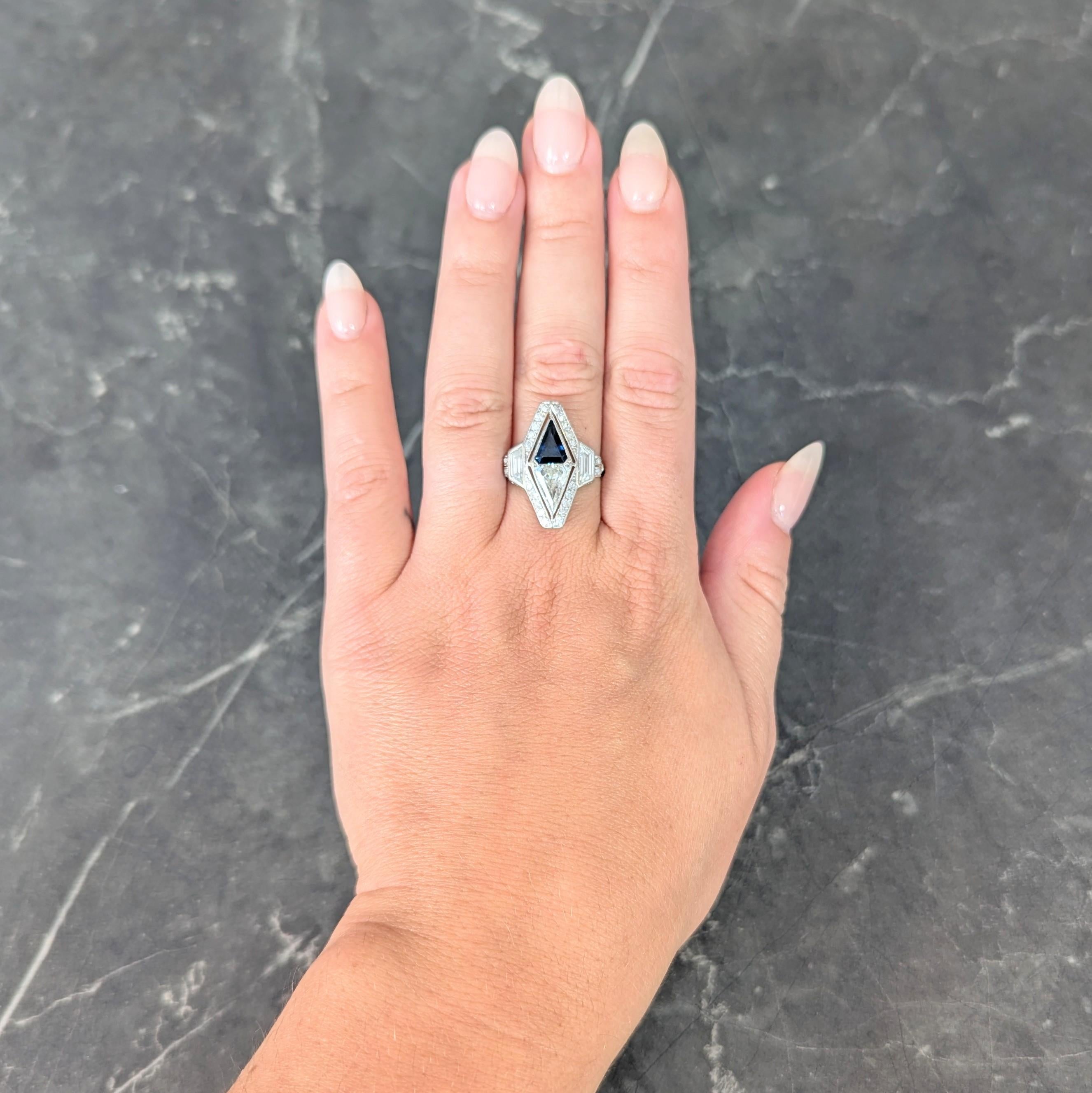 Centering pentagonal step-cut sapphire and diamond bezel set north to west toi-et-moi style
Sapphire weighs approximately 1.29 carats - transparent medium blue
Diamond weighs approximately 1.15 carats - M color with VS2 clarity
With a pierced halo