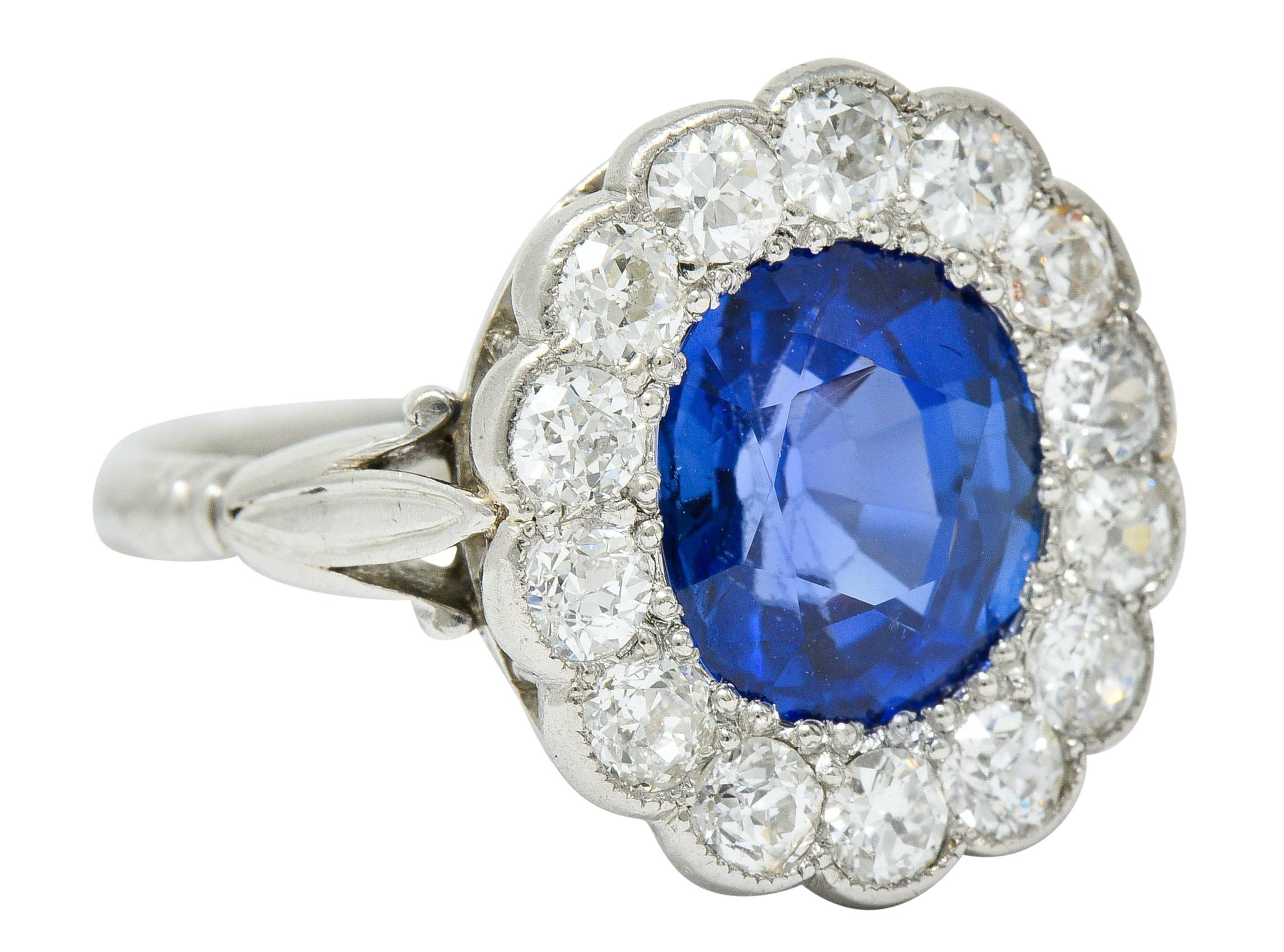 Cluster ring centers an oval cushion cut sapphire weighing 2.55 carats

Transparent with strong blue color

Surrounded by a scalloped halo of old European cut diamonds

Weighing in total approximately 1.00 carat with G to J color and SI
