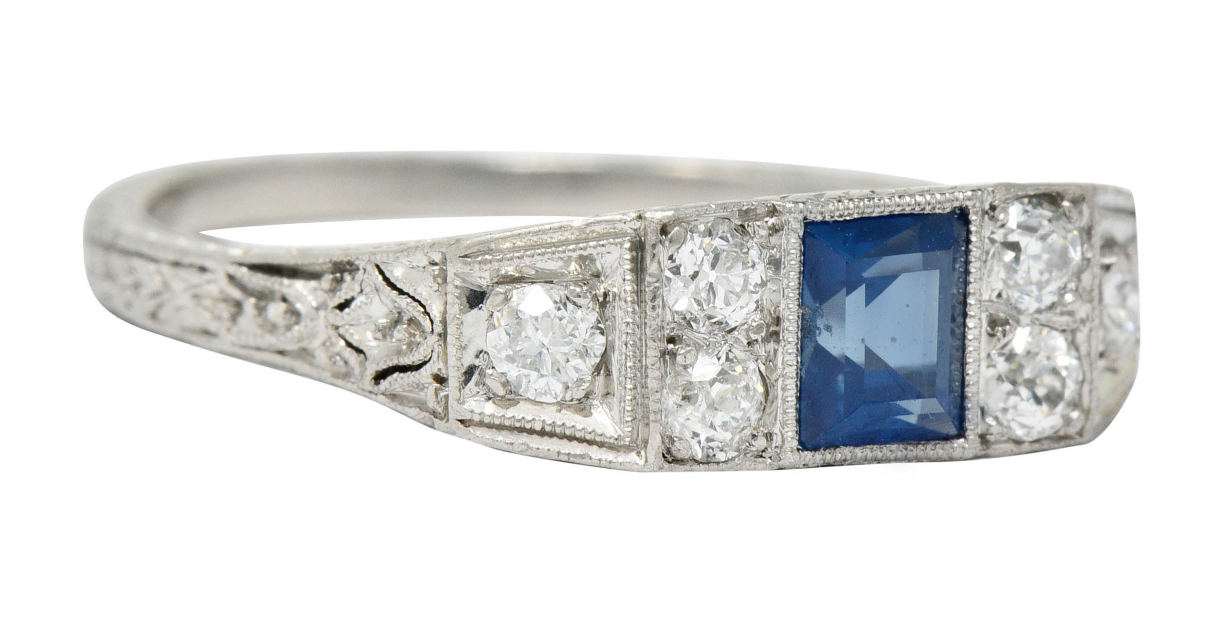 East/West style band ring centering a rectangular cut sapphire weighing approximately 0.50 carat; bright blue

Bezel set and flanked by old European cut diamonds weighing in total approximately 0.45 carat; G to I color with SI clarity

With a