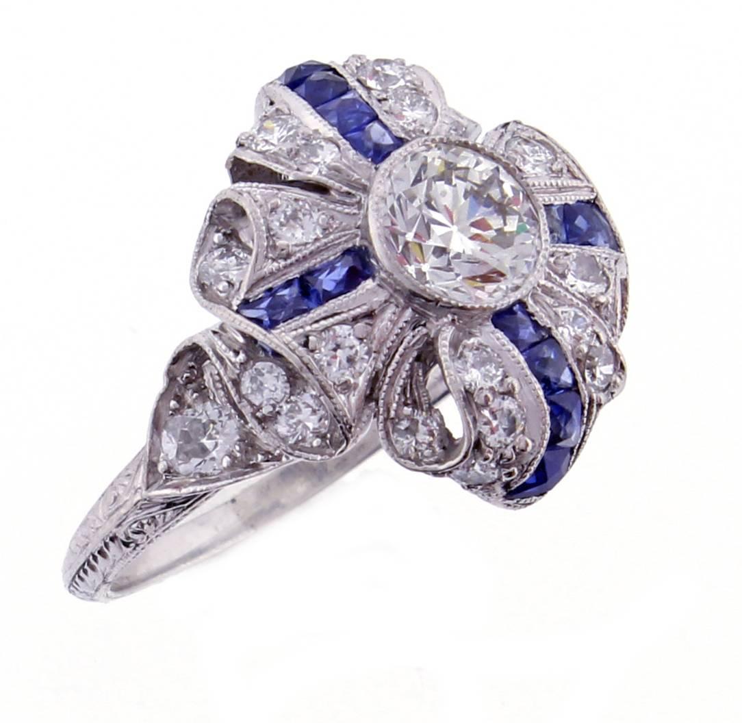 An exceptional example of Art Deco style and craftsmanship. The platinum ring is designed as a ribbon folding in upon itself. The center old European cut diamond weighs approximately .75 carat, H color and VS1 clarity.
Accented by 12 french cut