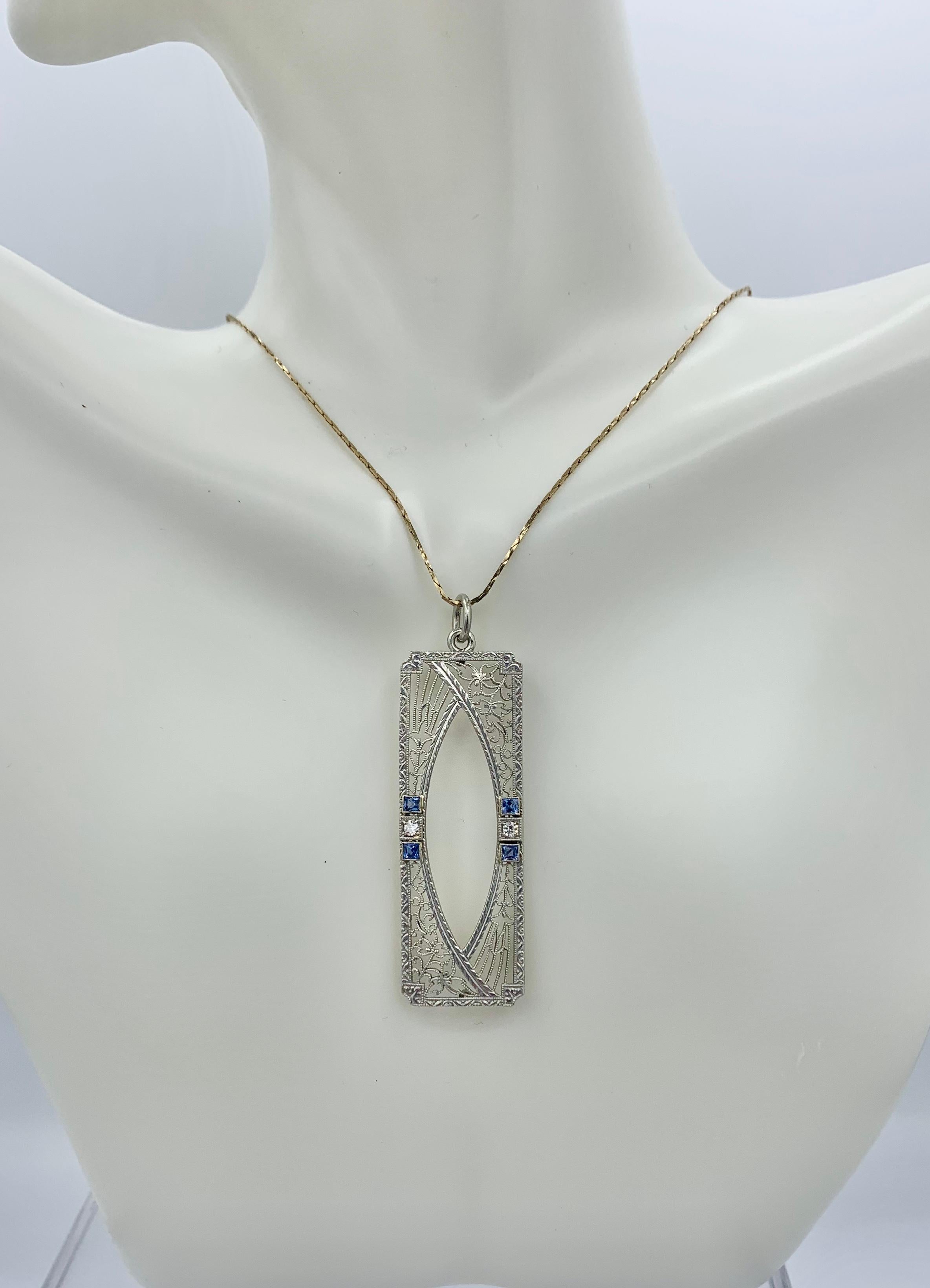 Indulge in a stunning Art Deco Sapphire Old Mine Cut Diamond Lavaliere Pendant in 14 Karat White Gold.   The lovely and delicate pendant is set with four beautiful square cut faceted Sapphire gems of a wonderful blue color.   Between the Sapphires