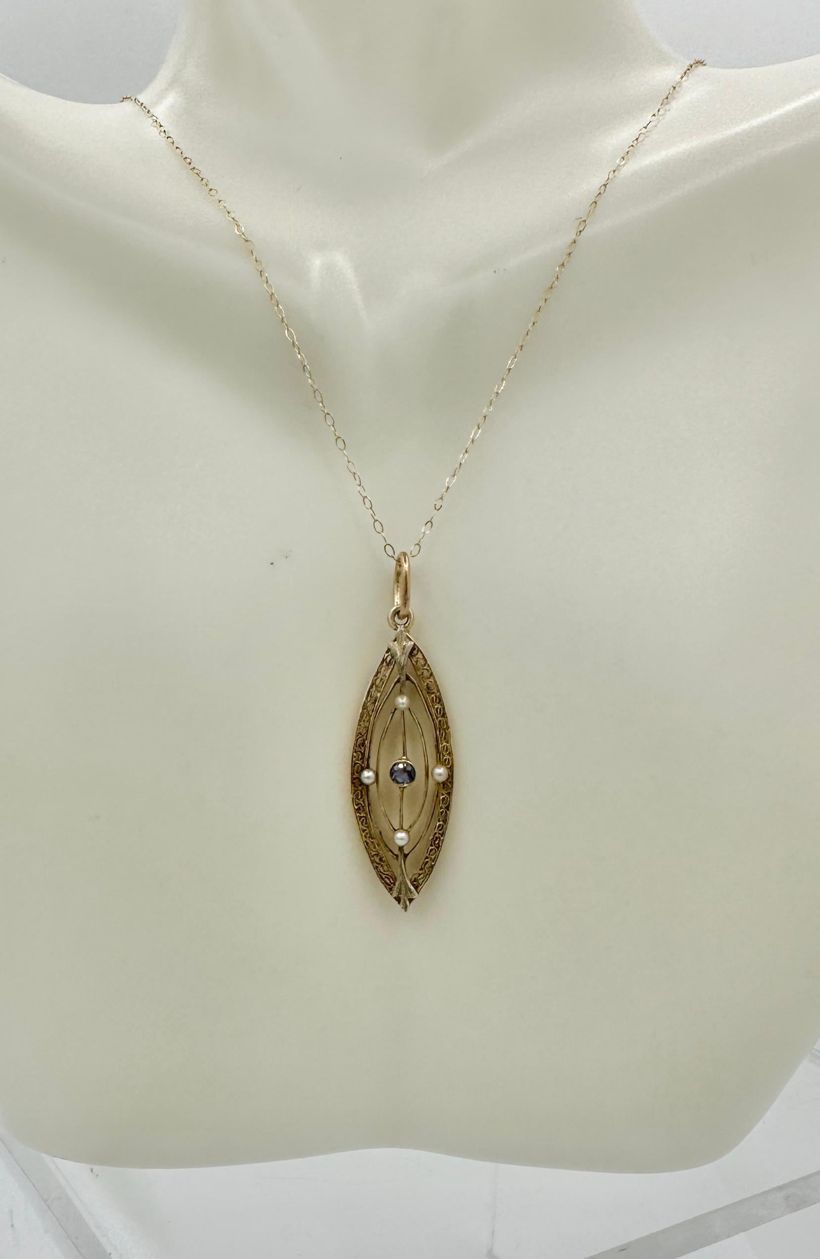 This is a beautiful Victorian - Art Deco Sapphire Pearl Lavaliere Pendant in 14 Karat Gold.   The lovely and delicate pendant is set with a beautiful round faceted Sapphire of a wonderful blue color.   The sapphire is set within a knife edge design