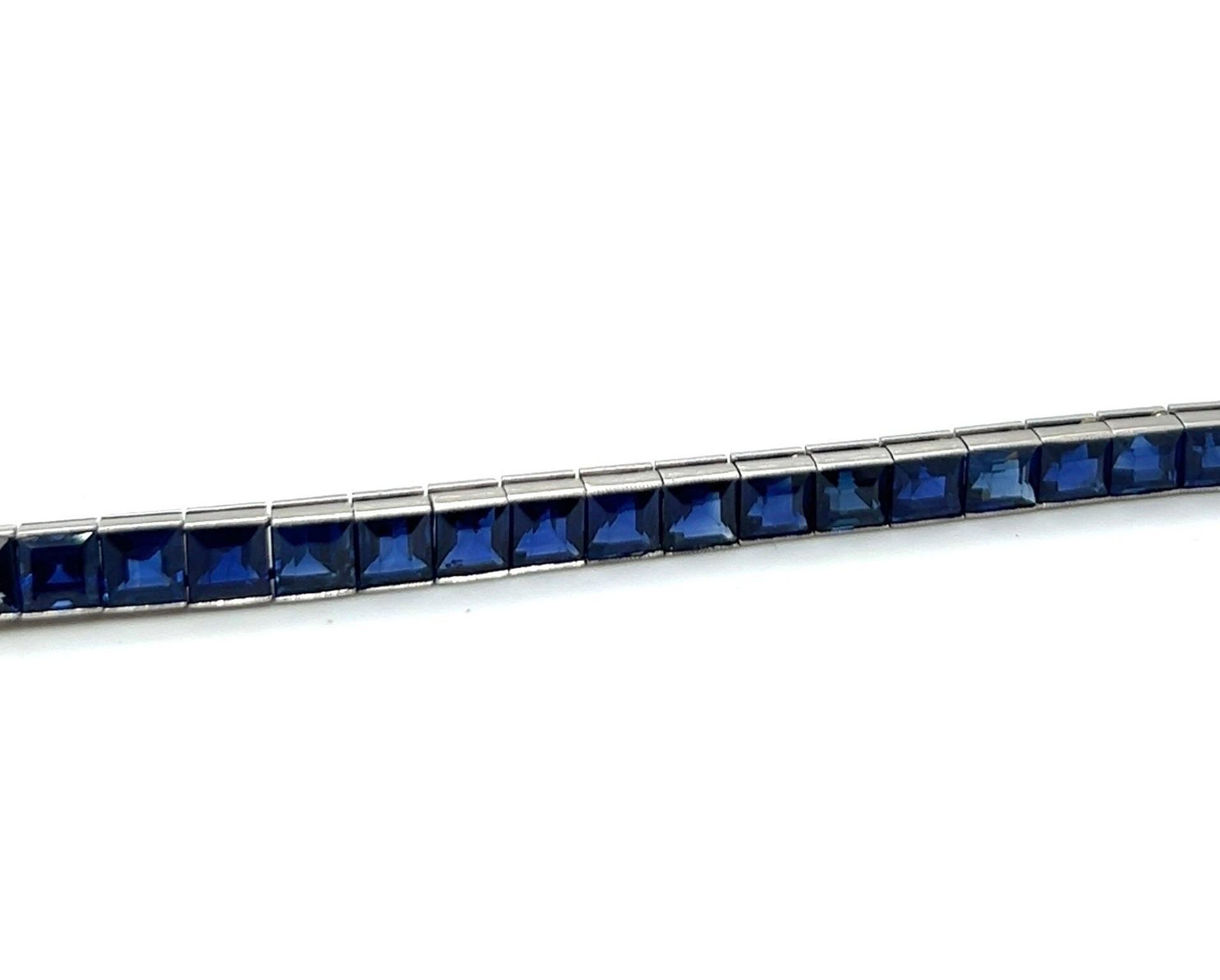 Attractive platinum and sapphire rivière/tennis bracelet from the Art Déco era.

Delightful platinum rivière/tennis bracelet, designed as a line of 37 luminous Cambodian blue sapphires carrés in millegrain setting totalling circa 18.5 carats. The