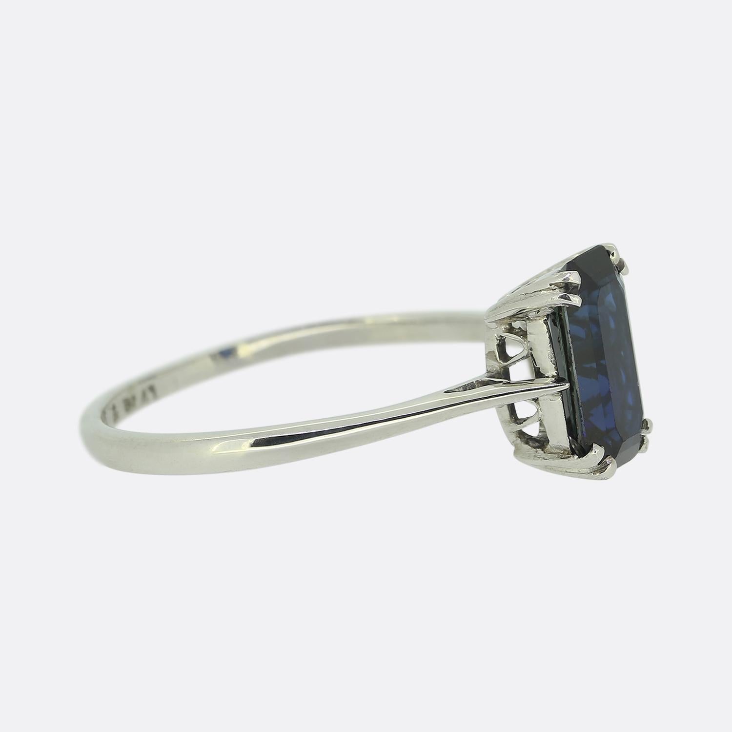 Here we have a classic sapphire solitaire ring dating back to the Art Deco era. The ring features a single emerald cut sapphire that sits in a four clawed mount. The sapphire is a mid to dark blue tone and although the band of the ring is 18ct white