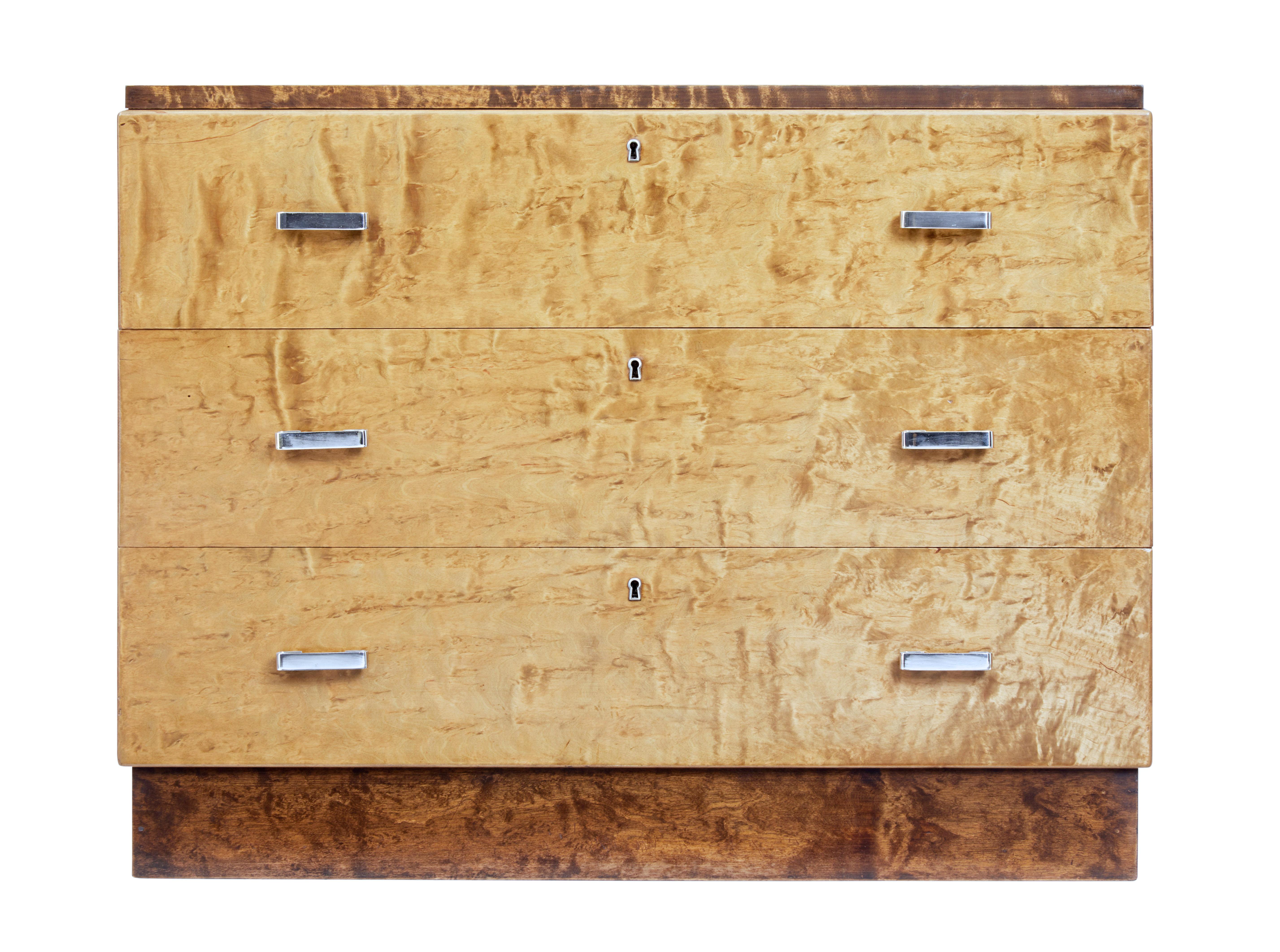 Art Deco Scandinavian birch chest of drawers, circa 1940.

Late Art Deco period chest of drawers fitted with 3 equal drawers and chromed handles. Two tone burr birch effect, with the darker top and plinth contrasting with the main body.

Narrow