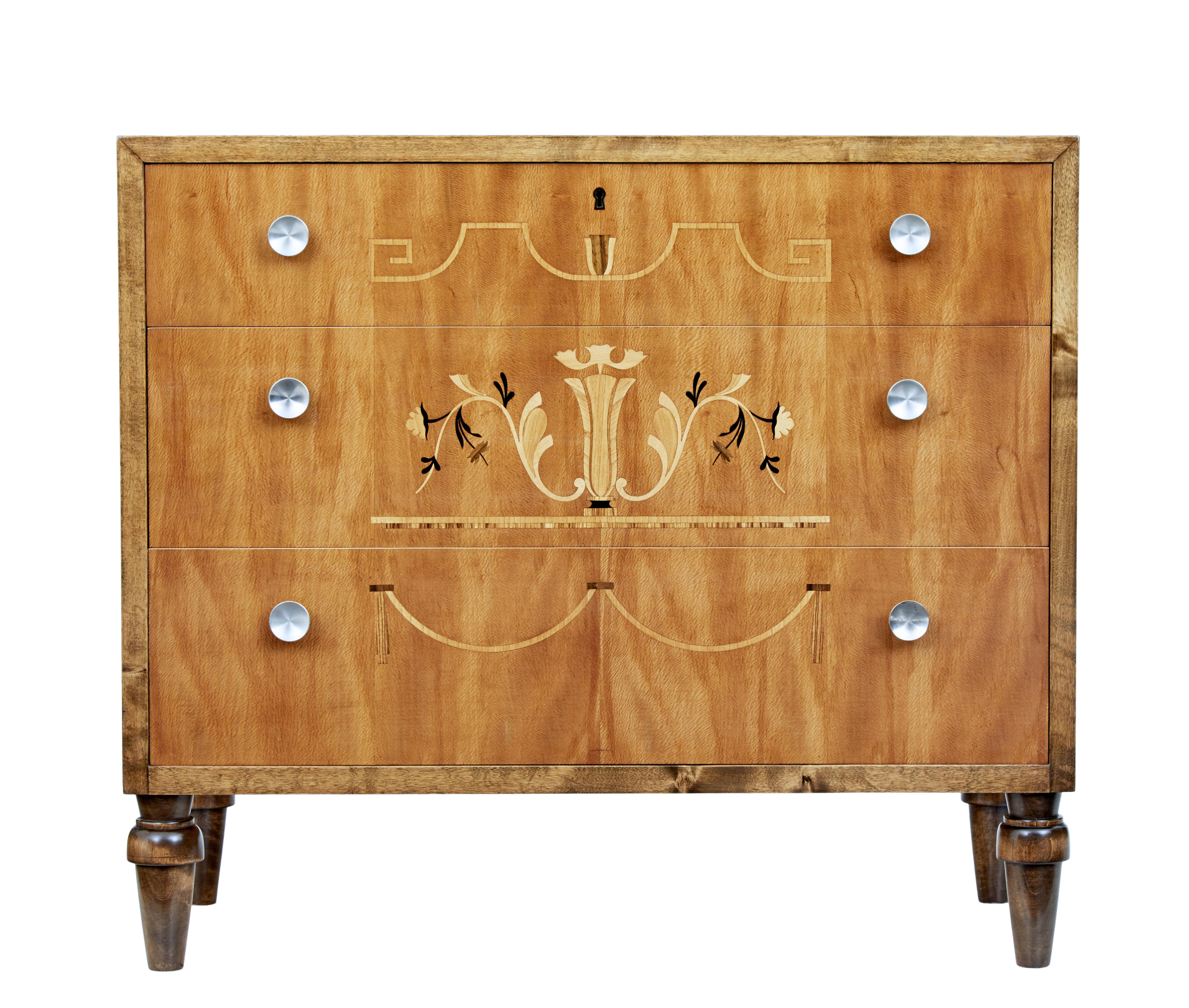 Art Deco Scandinavian birch inlaid chest of drawers, circa 1930.

Elegant Art Deco period chest of drawers. 3 graduating drawers each embellished with classical inlaid designs and fitted with brushed steel handles.

Outer birch carcass stained