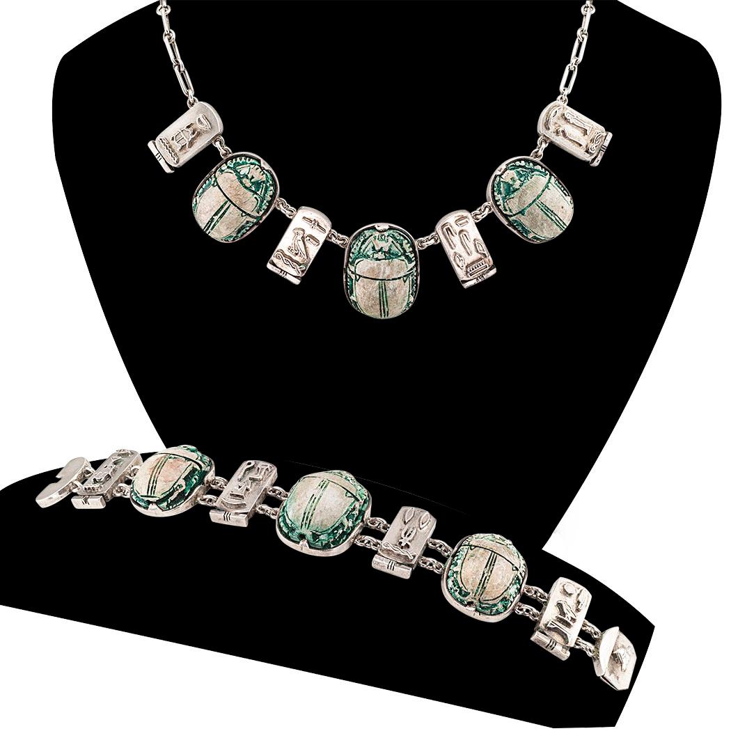  Art Deco Egyptian revival scarab faience and silver bracelet and necklace suite circa 1925.

DETAILS:
MATERIALS:  scarab-shaped faience (glazed earthenware or pottery) decorated on the front and back sides.

METAL:  silver.

MEASUREMENTS: 

       