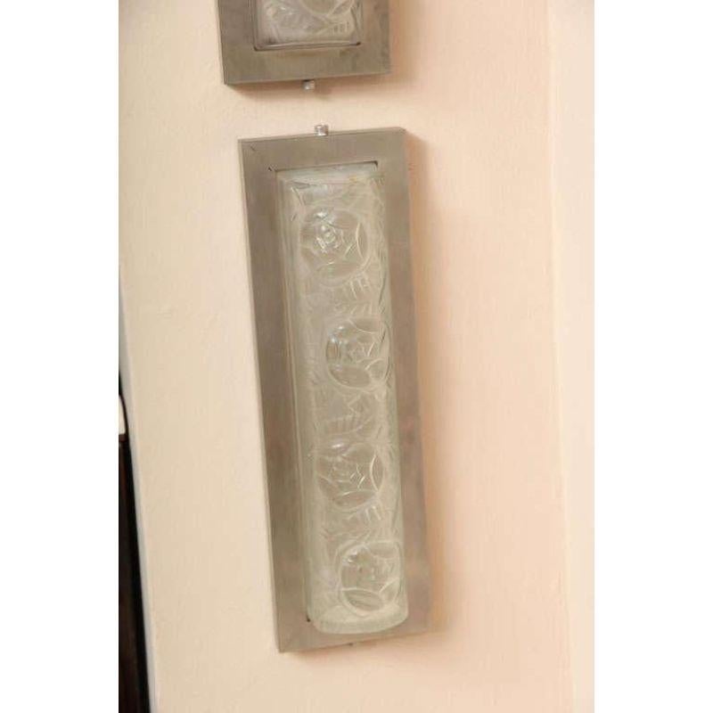 Verrerie D'Art Degue. French Art Deco wall sconces, 1930s. Clear and frosted glass shades molded with a floral motif and mounted in a modern brushed nickel frame. Measures: Height 13.5”, width 3.5”, depth 2”.