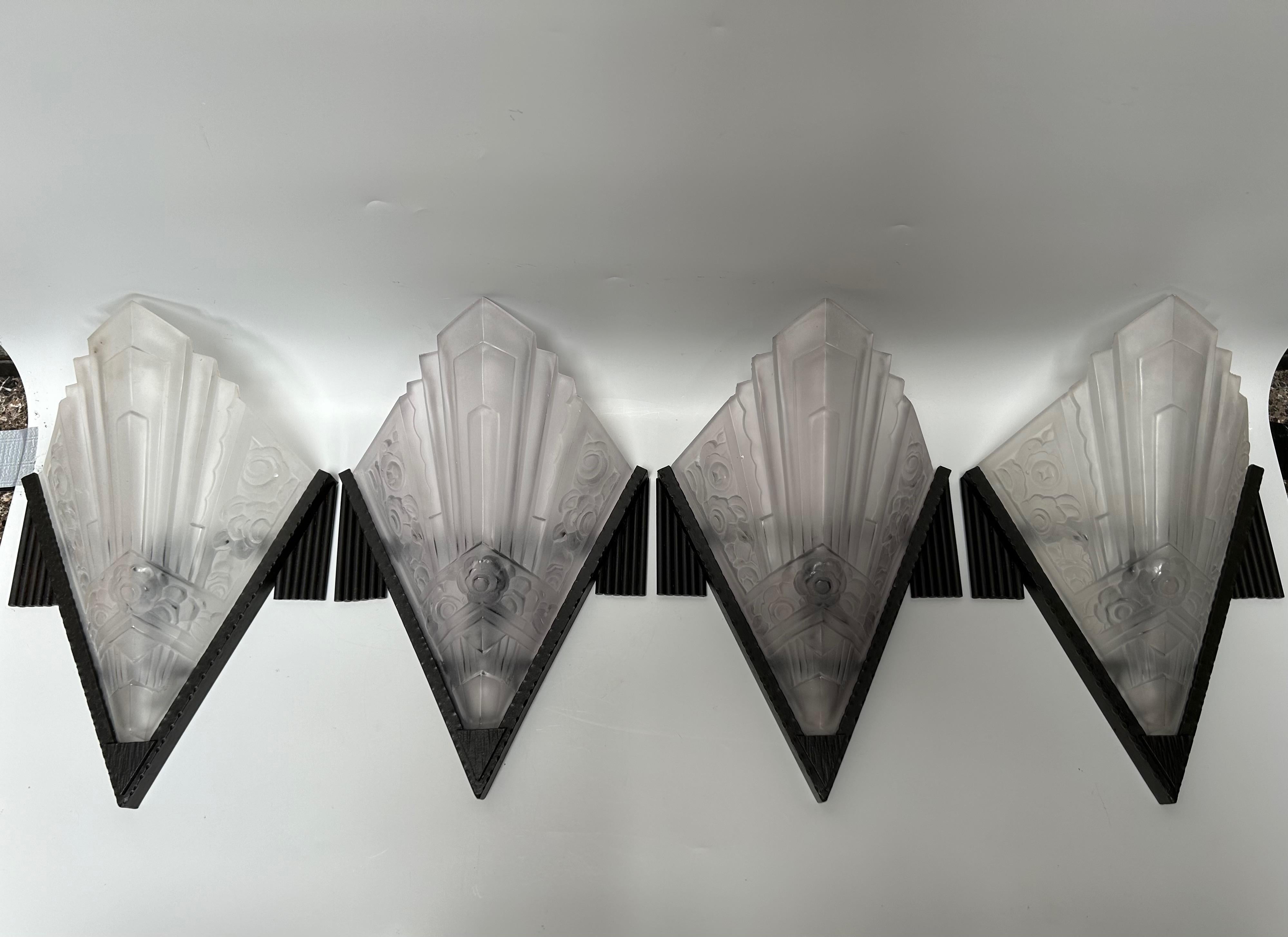 Suite of 4 art deco wall lights signed SEVB (Société d'Exploitation des Verreries de Bagneaux).
Pressed molded glass with floral decoration.
Wrought iron frame.
Electrified, E14 socket, screw bulb.
In perfect condition.

Height: 35cm
Width: