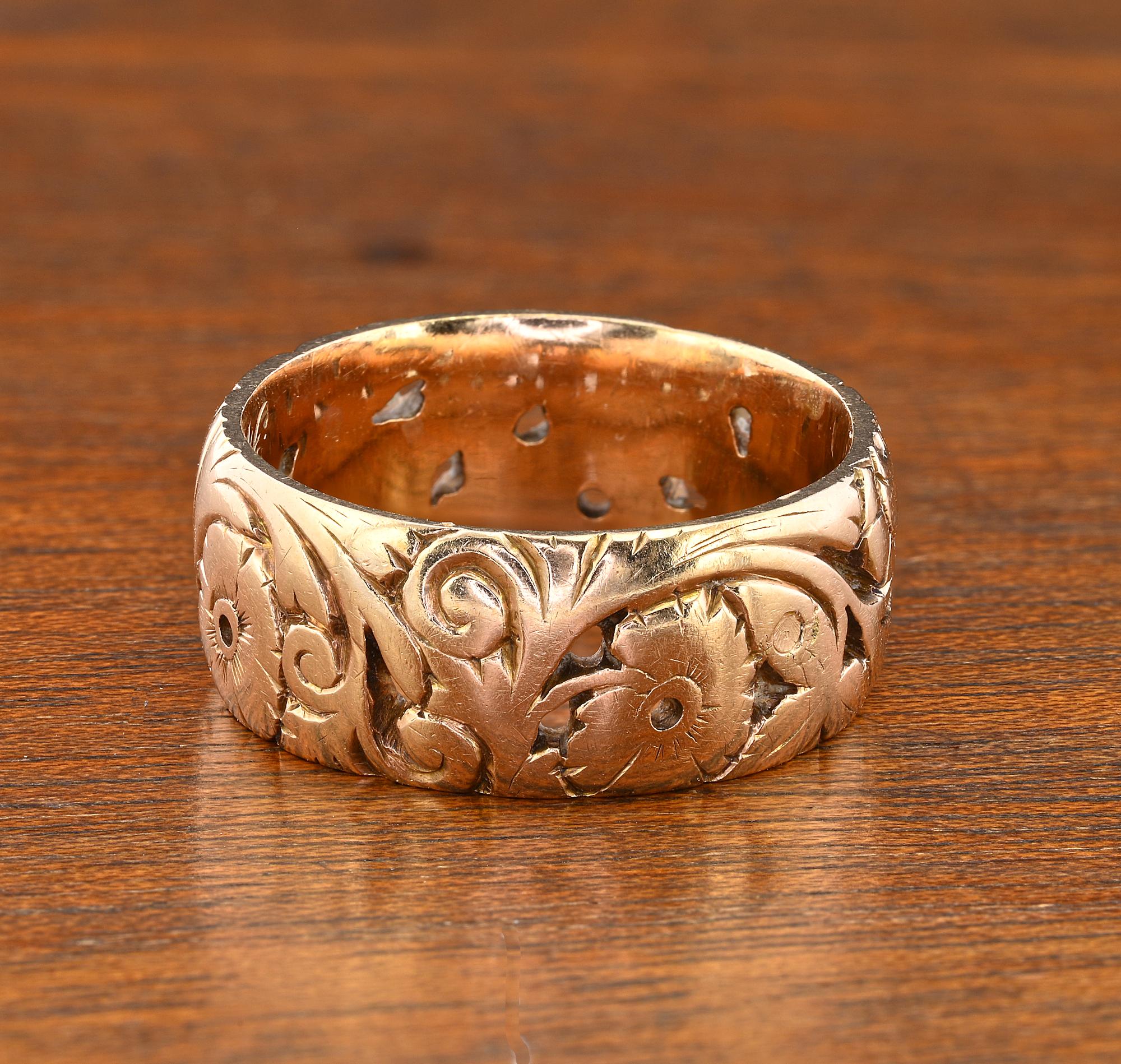 Questo meraviglioso anello antico 14 KT è disegnato come un'ampia fascia con splendidi motivi a volute arricchiti da fiori e fogliame riccamente dettagliati.
Inscritto 