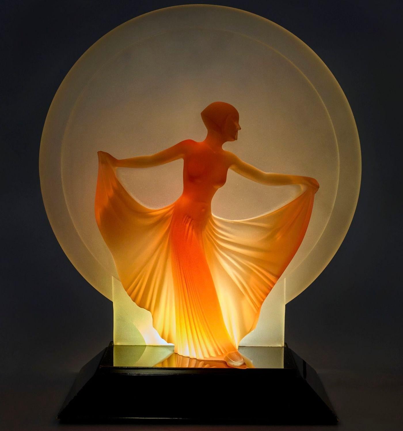 Alluring sculptural lamp made of resin depicting a young female dancer flowing her skirt. It's supported by a rectangular base and has a center round background. Made by Martin Russel, USA, 1989. It is numbered 2/50 of the edition.
Signed by the