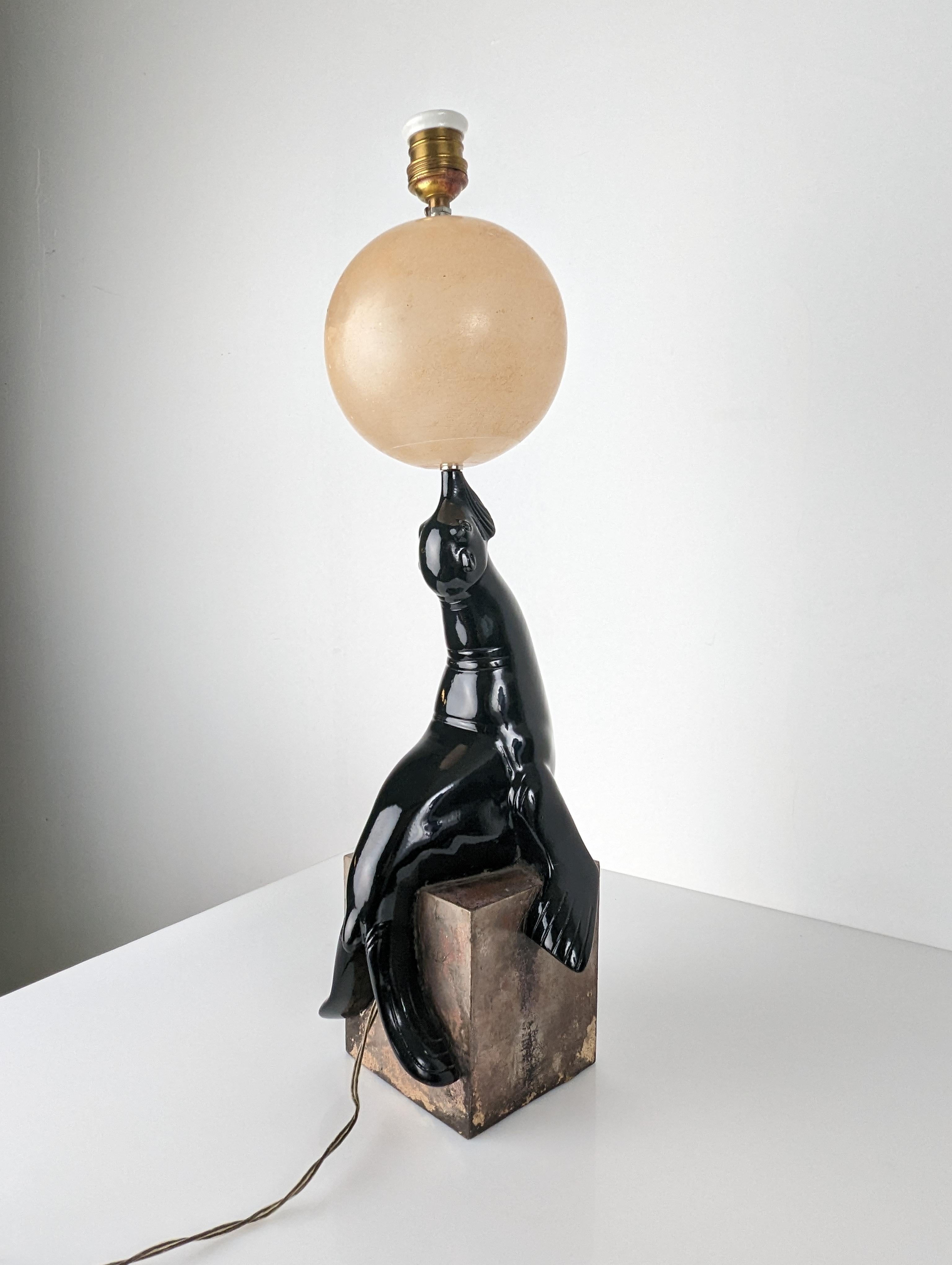 Lampe ancienne Art Déco attribuée au sculpteur français Marcel André Bouraine (1886-1948) représentant un phoque funambule sur un seau tout en tenant une boule d'albâtre. Fabriqué en métal chromé sur la base et d'une élégante couleur noire pour le