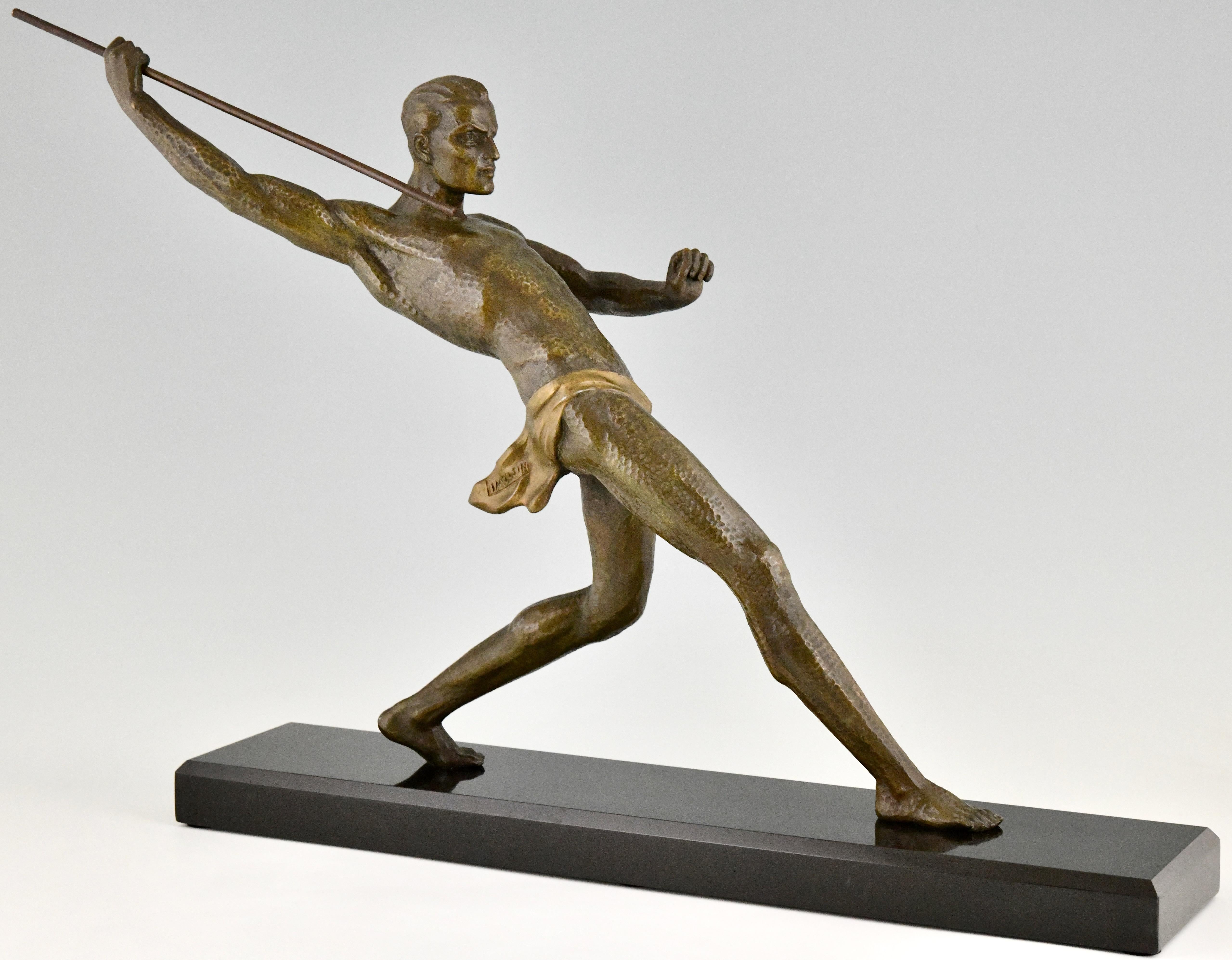 Sculpture Art Déco athlète avec lance, lanceur de javelot signée par Limousin. 
Métal d'art patiné sur une base en marbre noir belge. France 1930. 