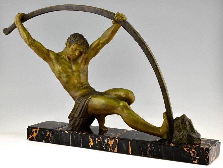 Impressive Art Deco sculpture of an athletic man bending a bar.
This work is titled 