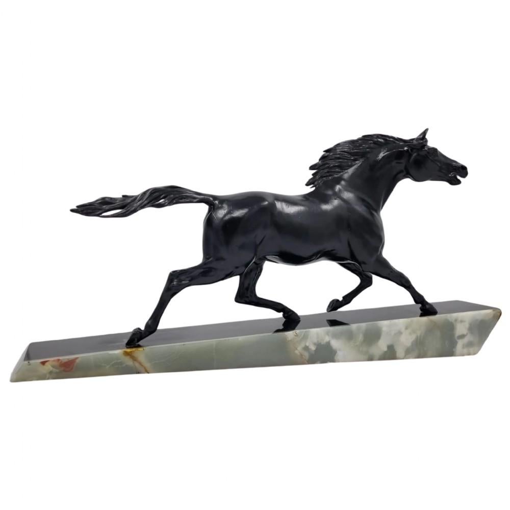 A breathtaking Art Deco sculpture capturing the movement and dynamics of a galloping horse, cast in cold painted spelter and gracefully mounted upon a sleek marble and onyx base. Created by an enigmatic artist of the Art Deco period, signed 