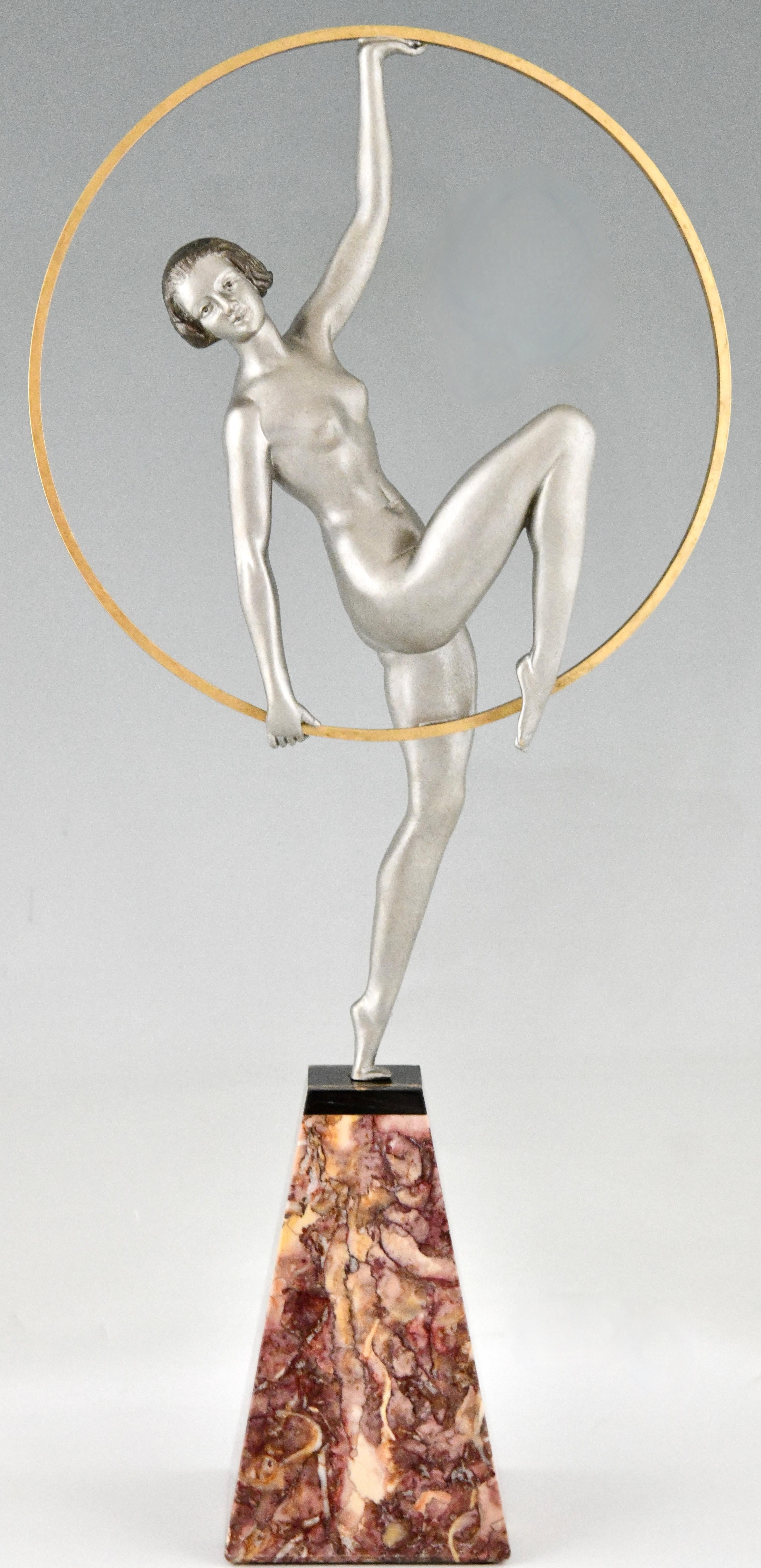 Sculpture Art déco de danseuse sur cerceau du Limousin.
Métal d'art patiné. 
Sur Portor et socle en marbre rose. 
France 1930. 