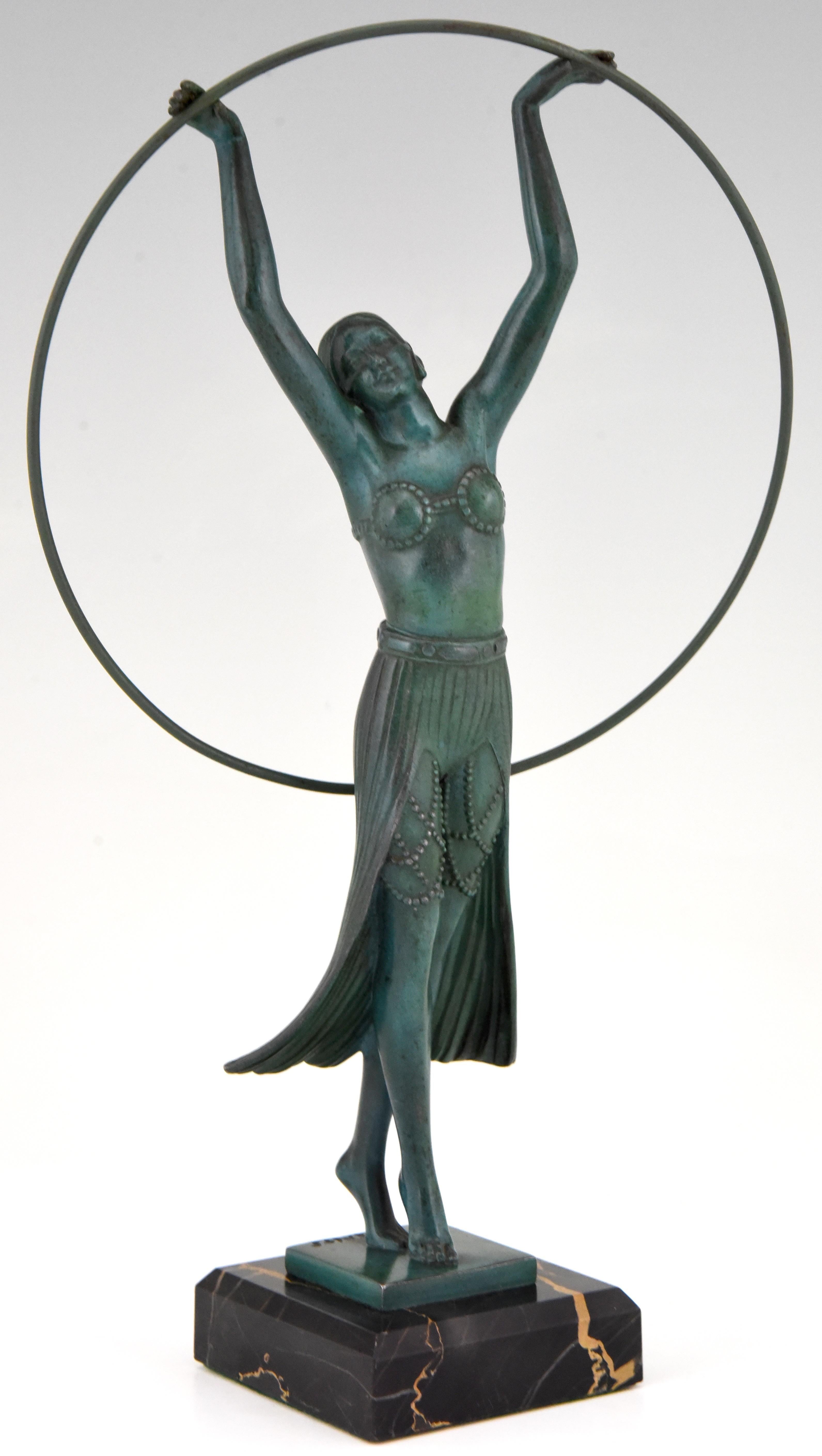 Elegant Art Deco sculpture of a woman with hoop signed by the French artist C. Charles, cast at the Max Le Verrier foundry.
The art metal sculpture has a lovely green patina and stands on a Portor marble base, circa 1930. 

Literature:
“The