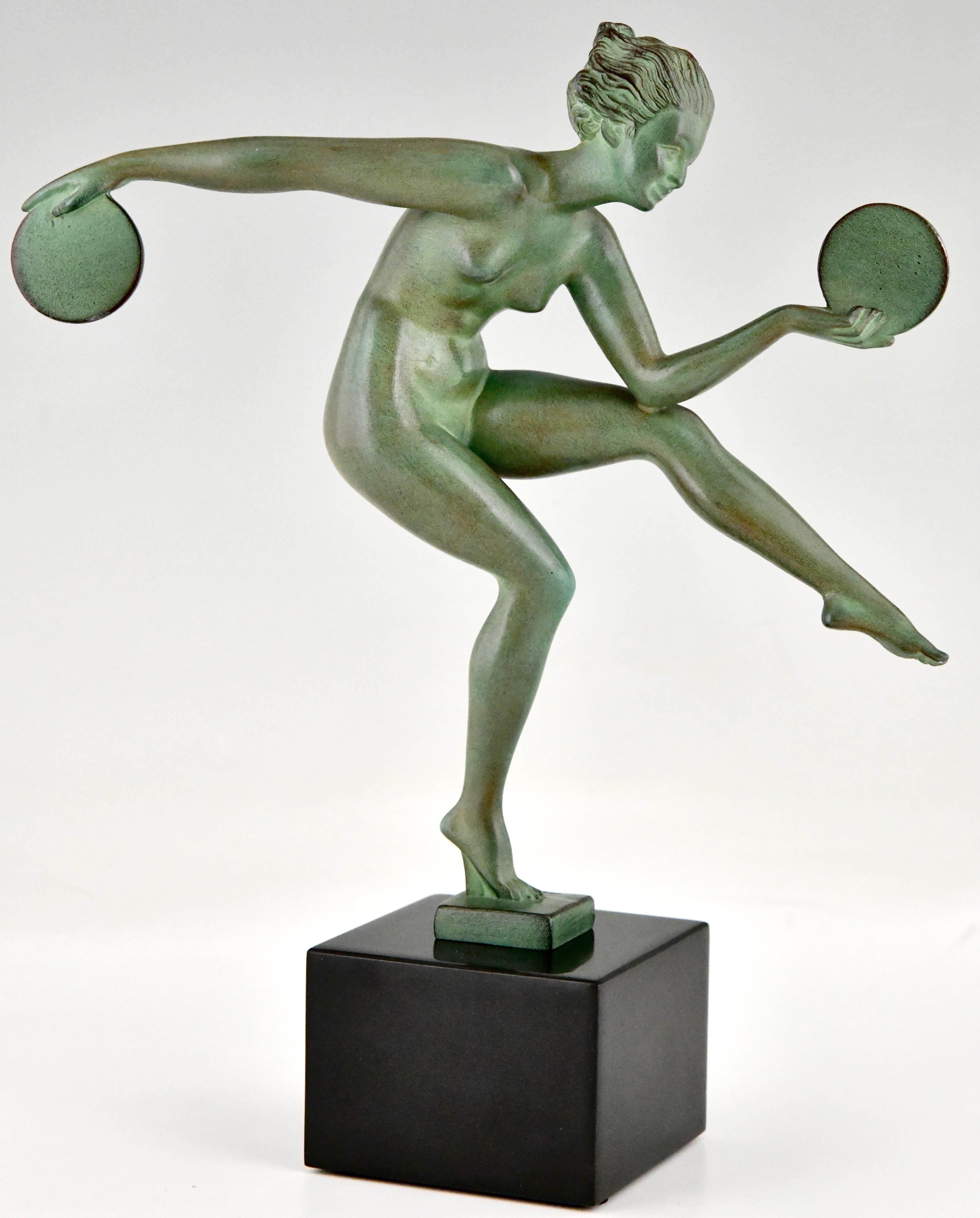 Art Deco sculpture nude disc dancer by Derenne.
Pseudonym used by Marcel Bouraine for his art metal sculptures cast by the Max Le Verrier foundry.
The sculpture is executed in Art metal with a green patina and is mounted on a Belgian Black marble