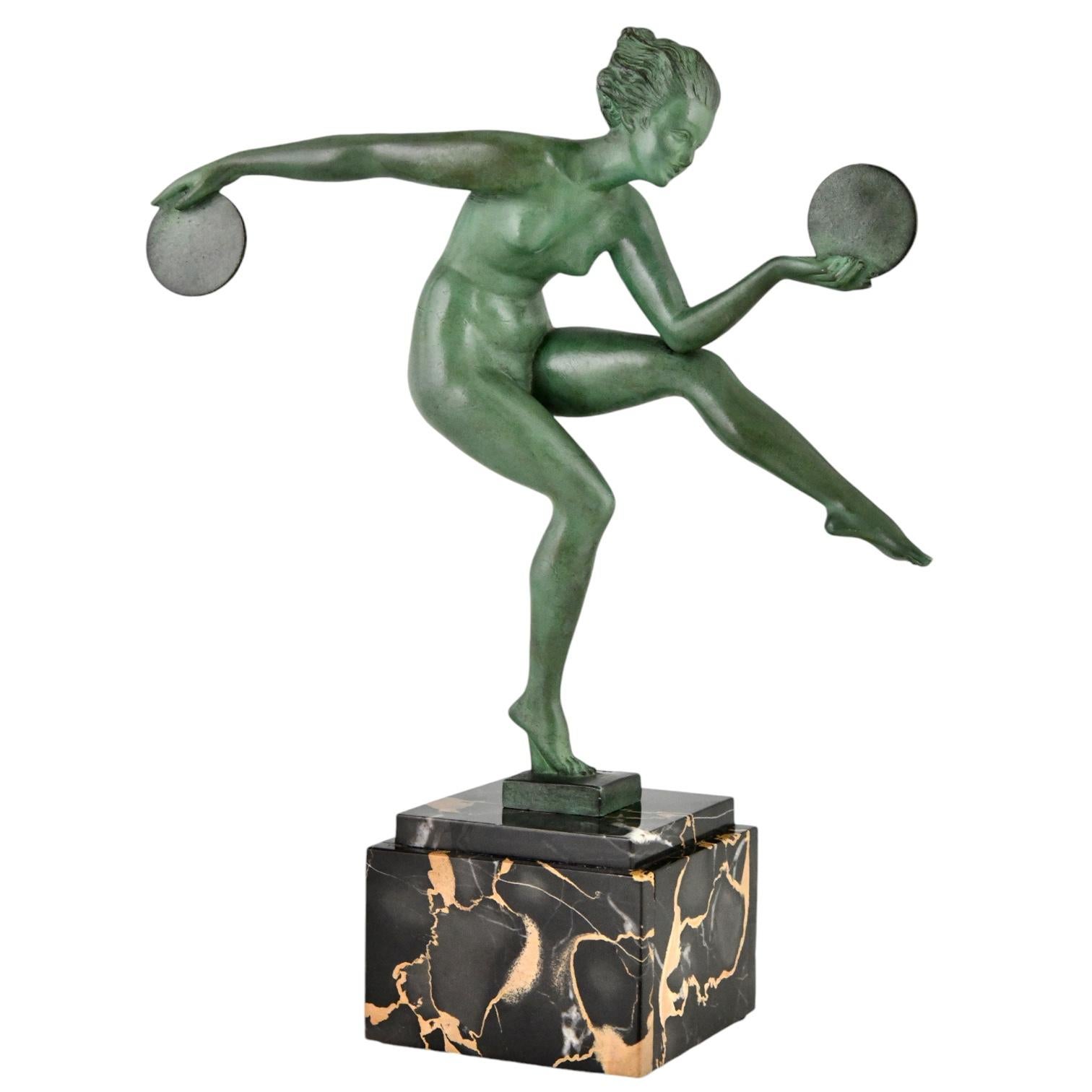 Art Deco sculpture nude disc dancer by Derenne.
Pseudonym used by Marcel Bouraine for his art metal sculptures cast by the Max Le Verrier foundry.
The sculpture is executed in Art metal with a green patina and is mounted on a Portor marble base.