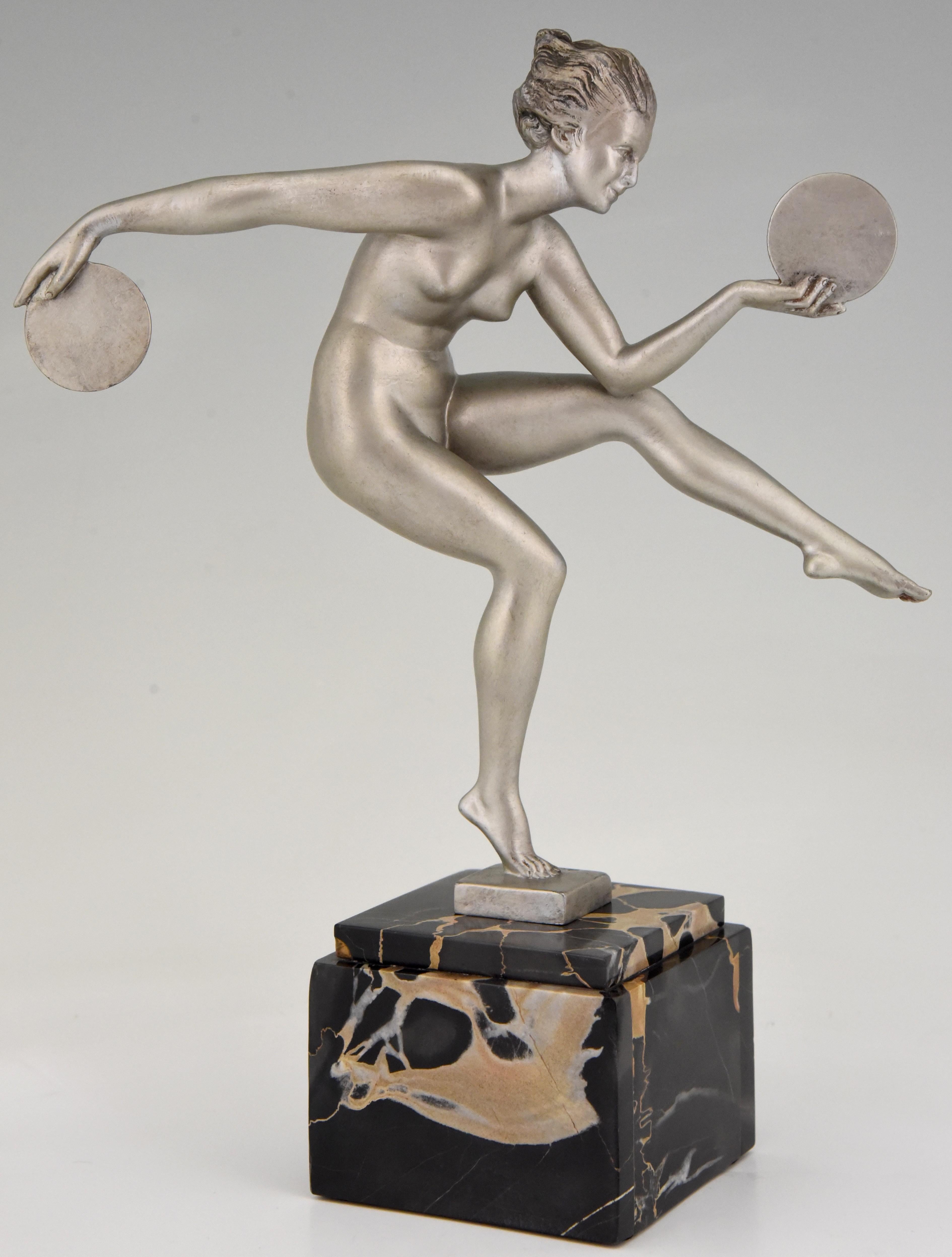 Elegant Art Deco sculpture of a dancing nude with discs by Derenne, pseudonym of Marcel Bouraine for his art metal sculptures cast by the Max Le Verrier foundry, France, 1930.
The art metal sculpture has a silver patina and stands on a Portor