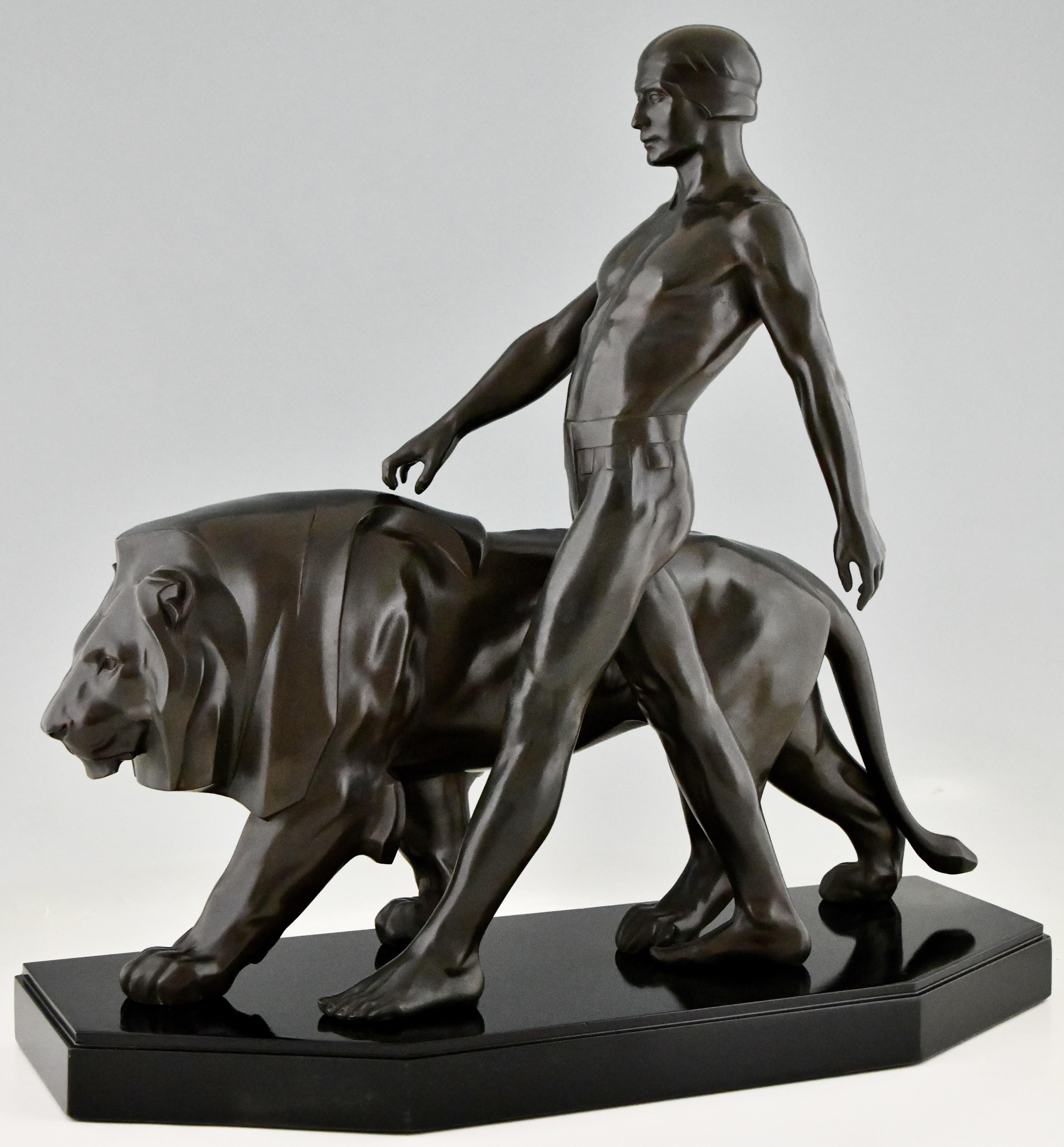 Art Deco sculpture of a male nude walking with lion. Belluaire, Art Deco sculpture modelled as an athletic male walking alongside a stylized lion signed by Max Le Verrier. France ca. 1925. Patinated Art metal on a Belgian Black marble base.