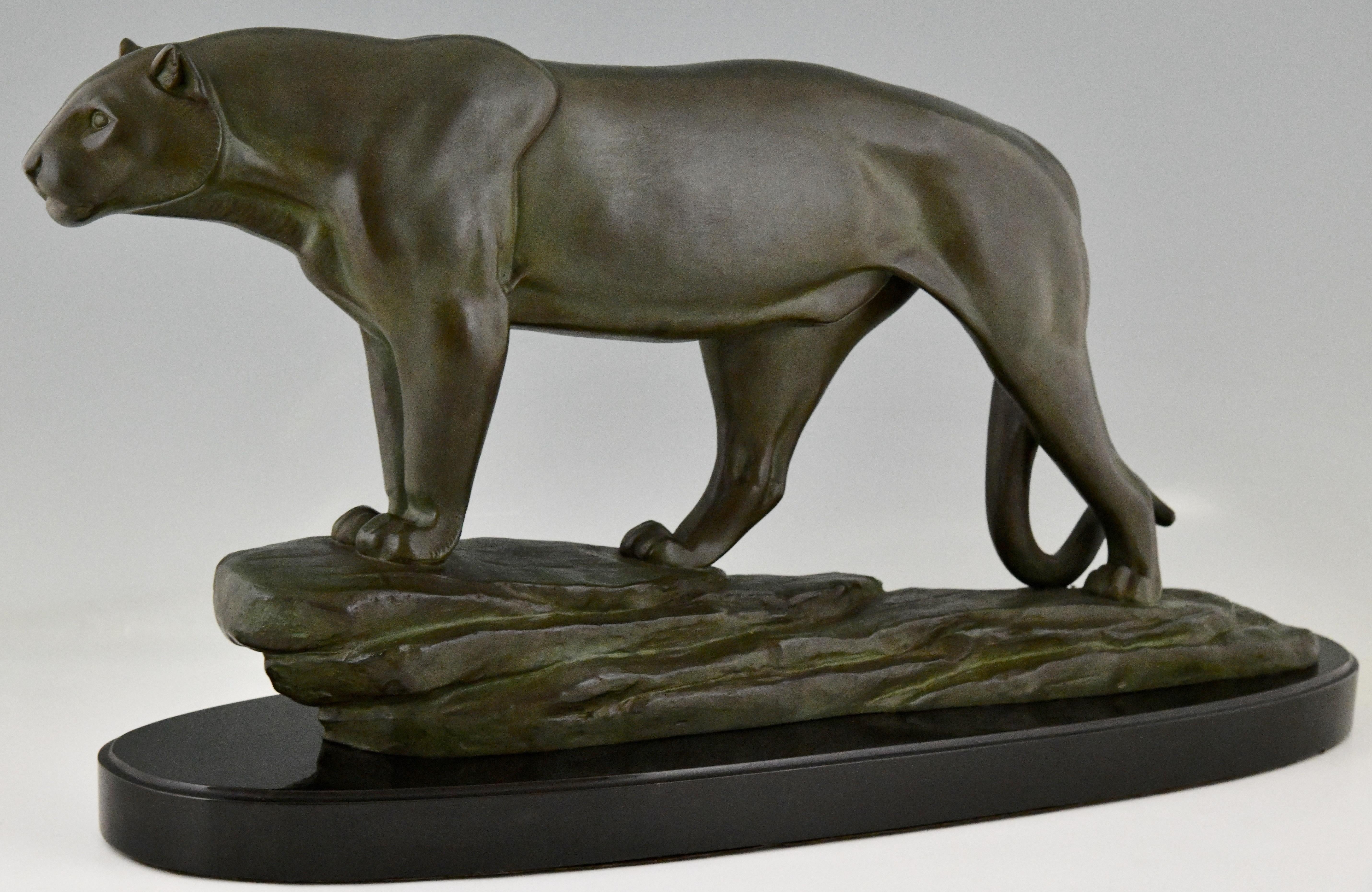 Sculpture Art déco d'une panthère signée Cham, pseudonyme de Rulas, sculpteur ayant travaillé en France de 1920 à 1930. Métal patiné sur un socle en marbre noir belge. 
Une taille impressionnante.