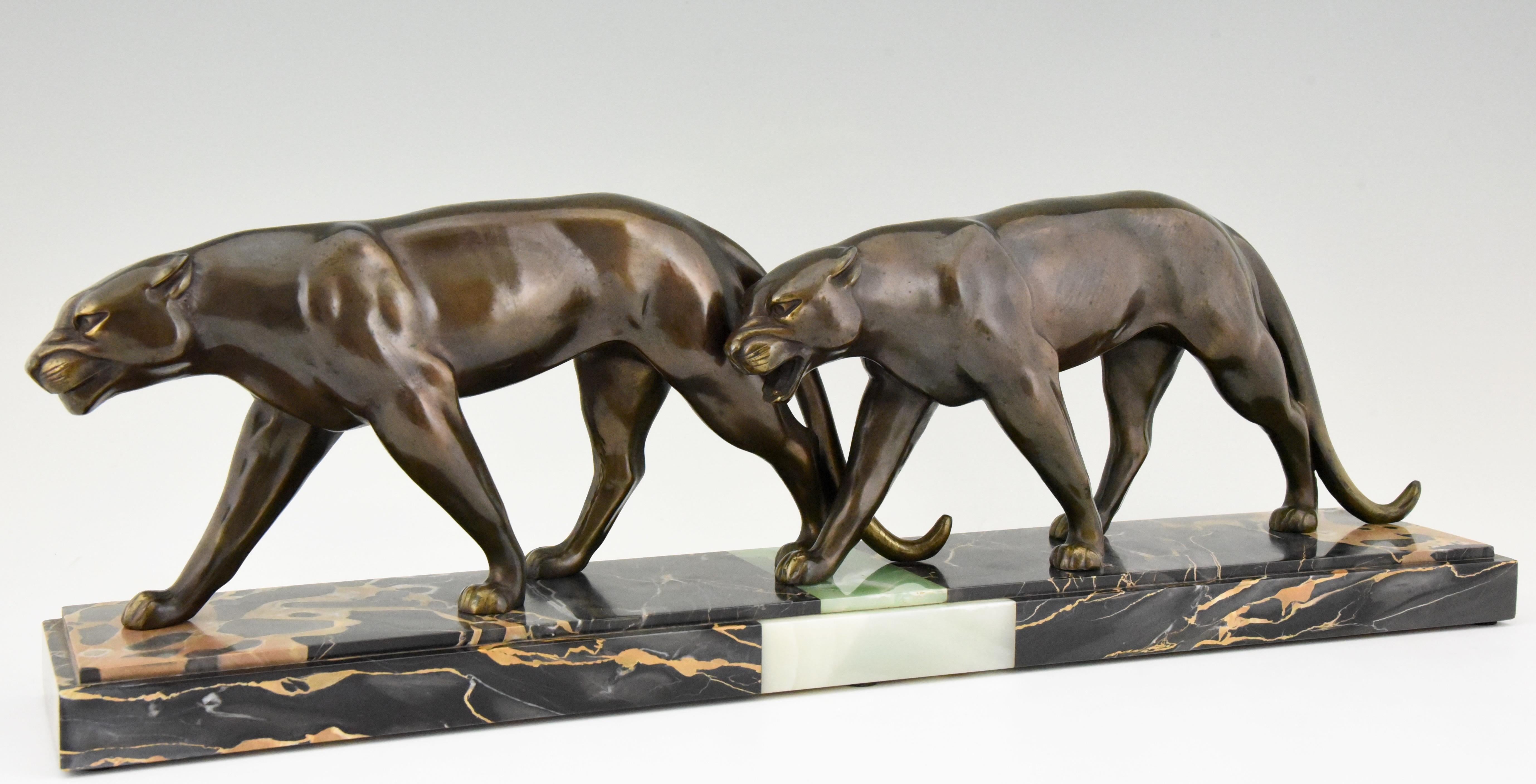 Art Deco sculpture of two walking panthers by Louis Albert Carvin. The panters are in patinated Art metal and are mounted on a fine Portor marble and onyx base, France, 1930

Literature:
“Animals in bronze” by Christopher Payne. Antique