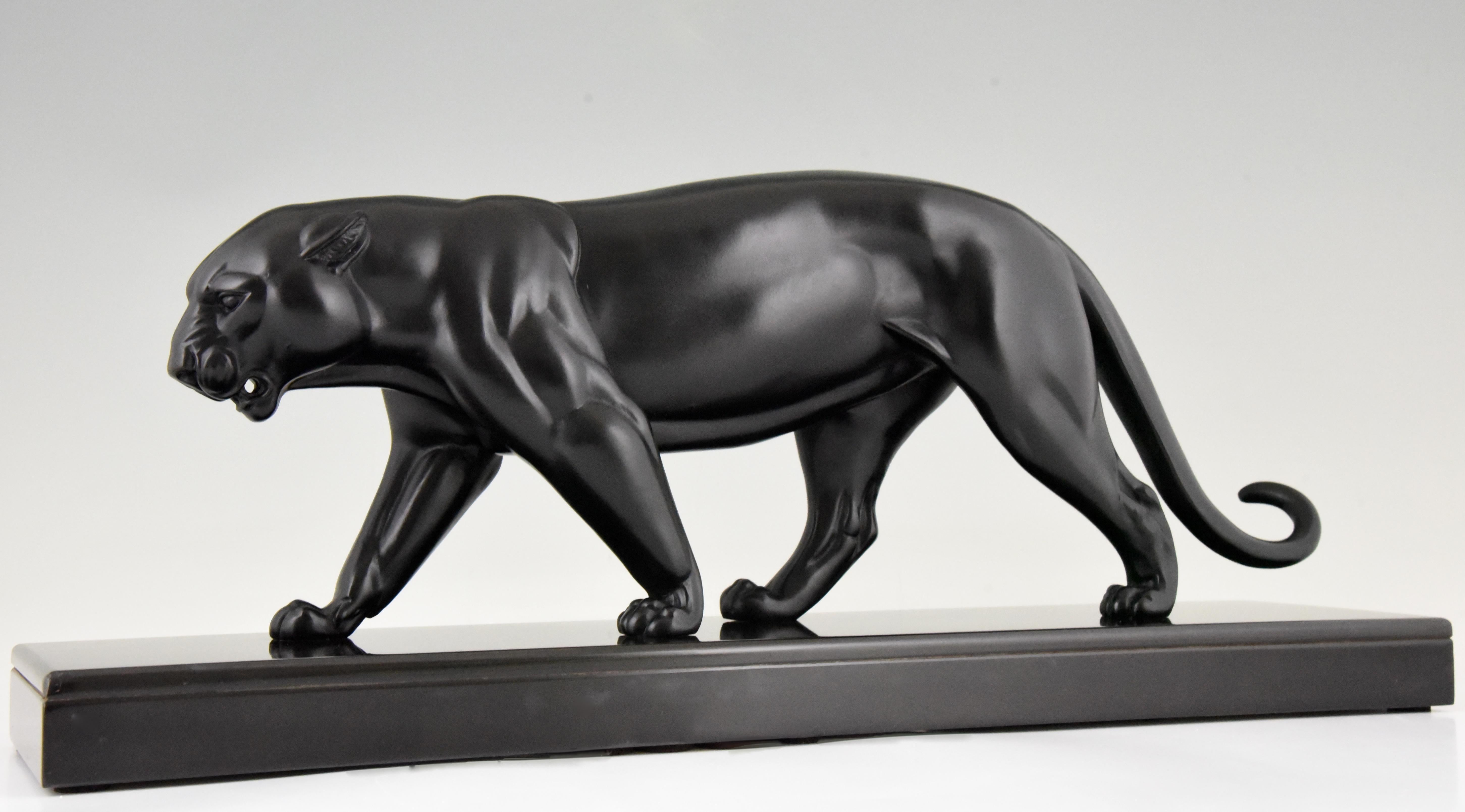 Sculpture Art déco élégante d'une panthère noire en marche. Métal d'art patiné sur base en marbre noir belge. Signé par Irénée Richard, France, 1930.

La littérature :
Animaux en bronze par Christophe Payne. Club des collectionneurs d'antiquités.