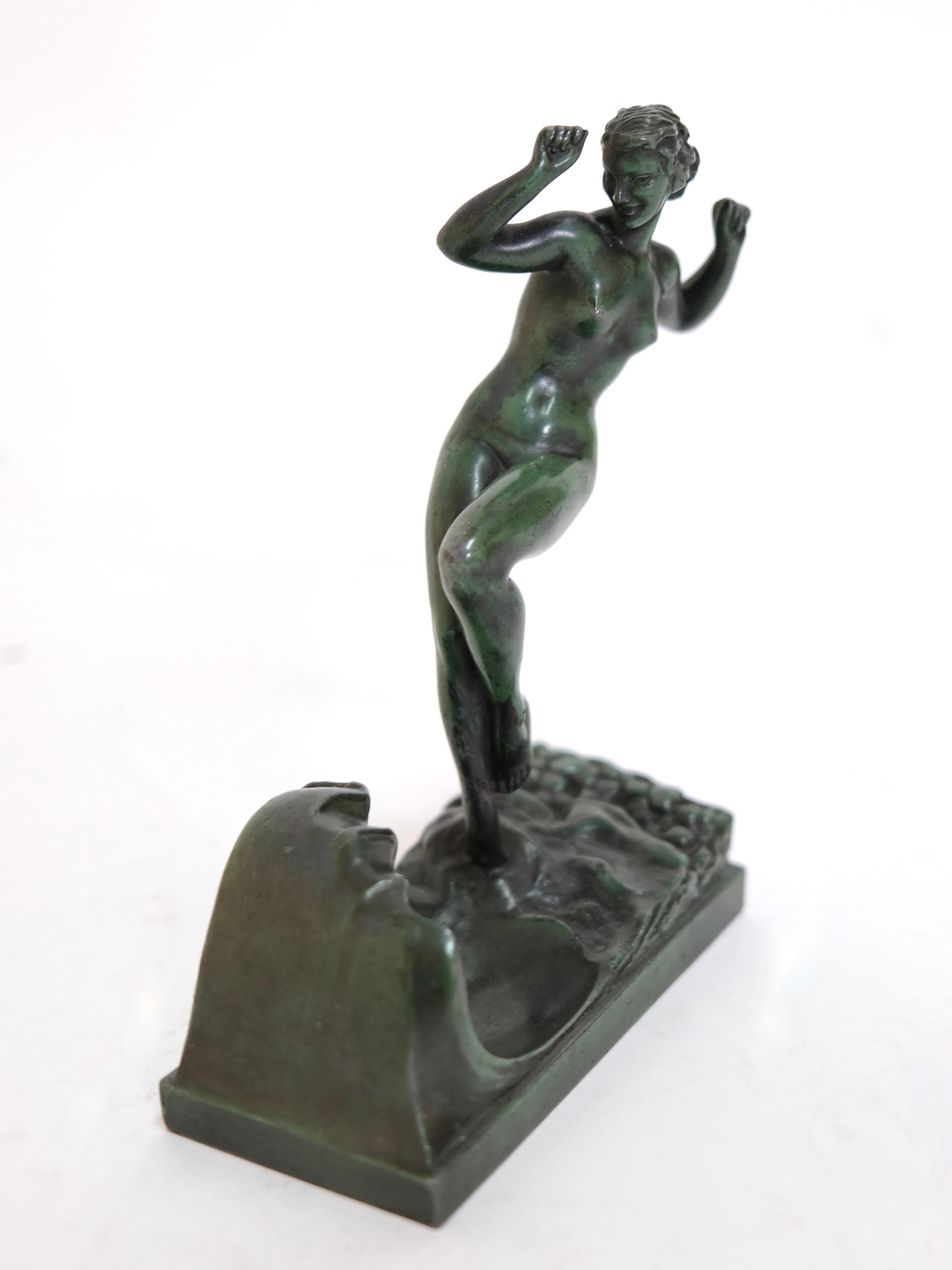 Who doesn't love a sunny-lazy day at the beach. 
This girl is a bit scared of the cold water. 
Bathing lady playing with a wave. 

Decorative little sculpture named Vague (engl. wave) 

Designed in France during the roaring 1920s by Raymonde